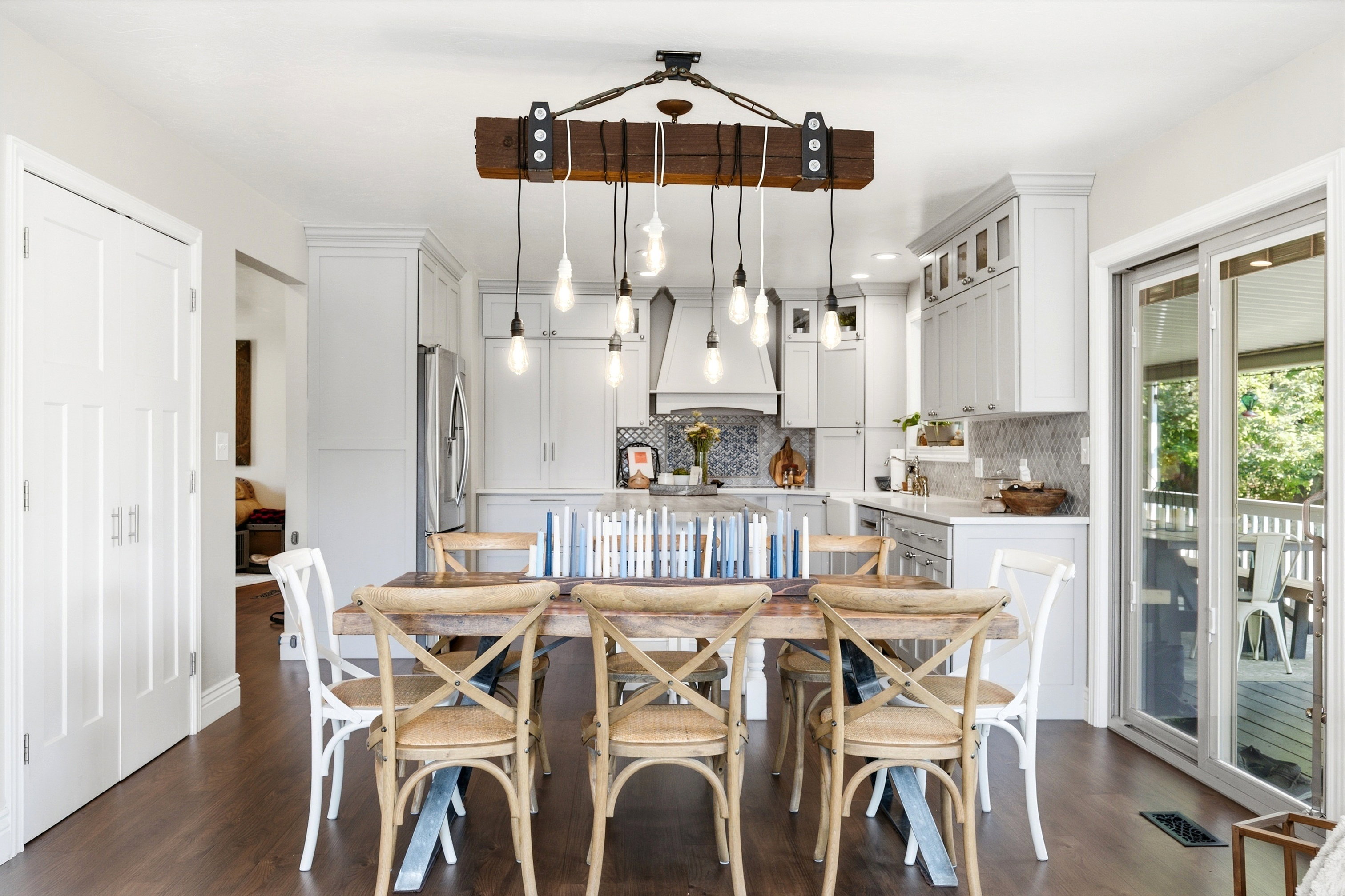 Open-concept living space featuring wood-finish flooring, a rustic-style chandelier, and white shaker cabinetry