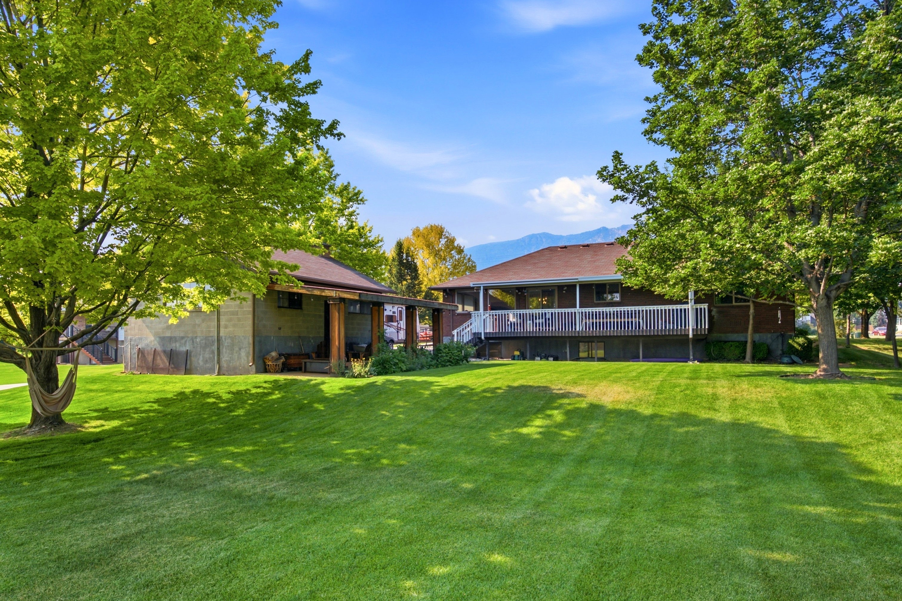 Expansive, manicured lawn with mature shade trees