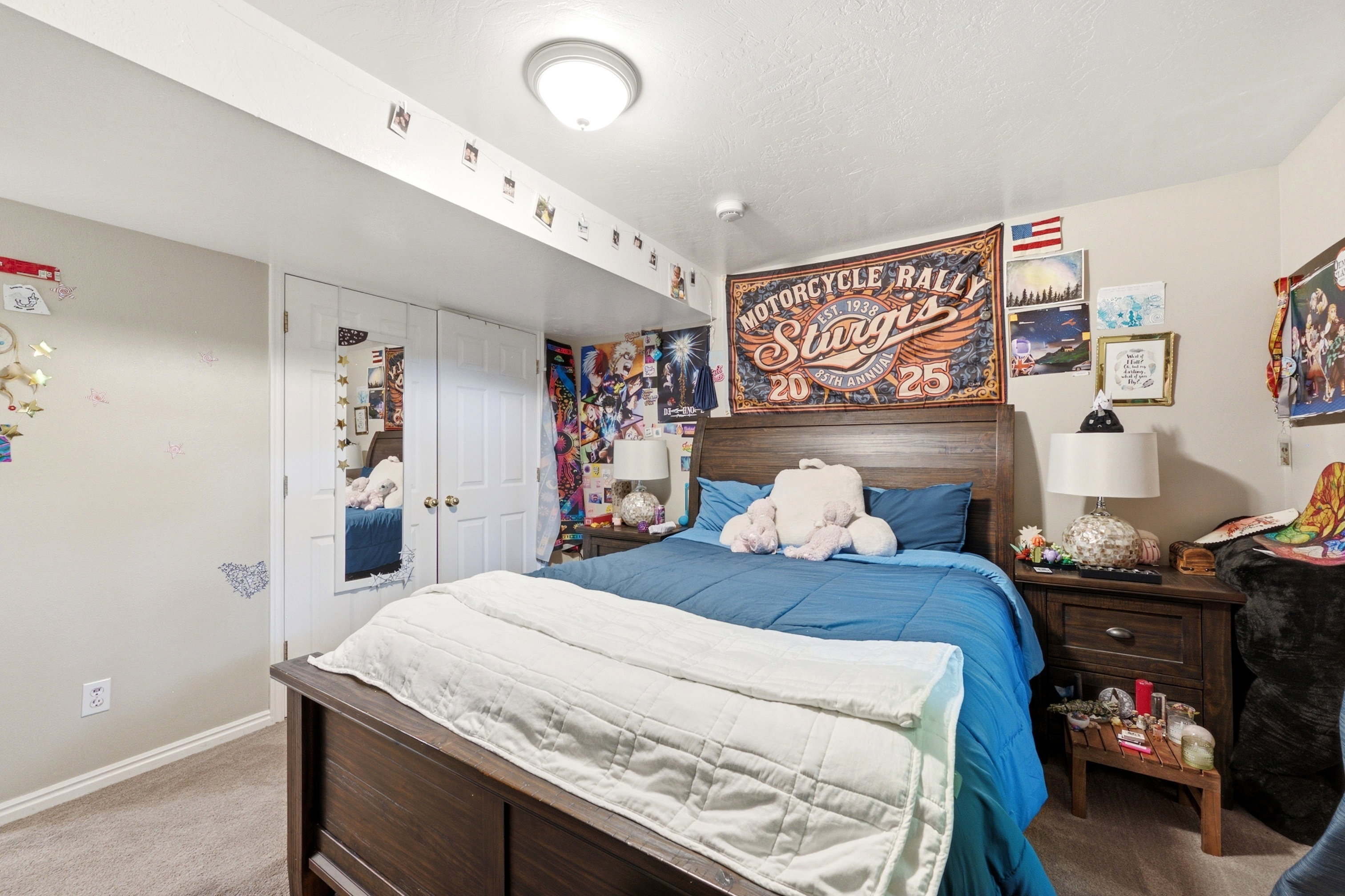 Carpeted room with a ceiling-mounted light fixture, featuring double-door closet with one mirrored panel