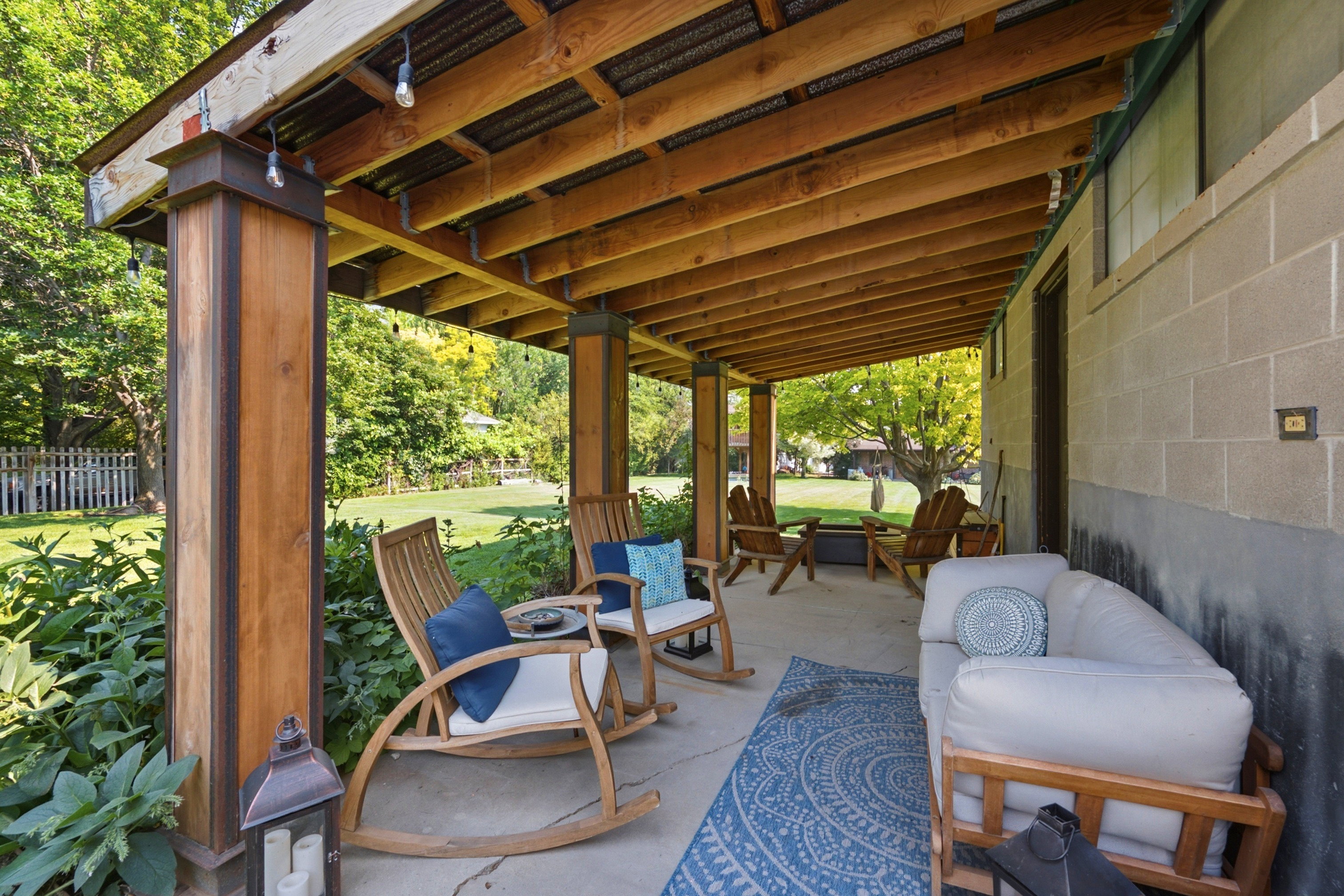 Expansive covered patio featuring a concrete surface and exposed wood beam ceiling