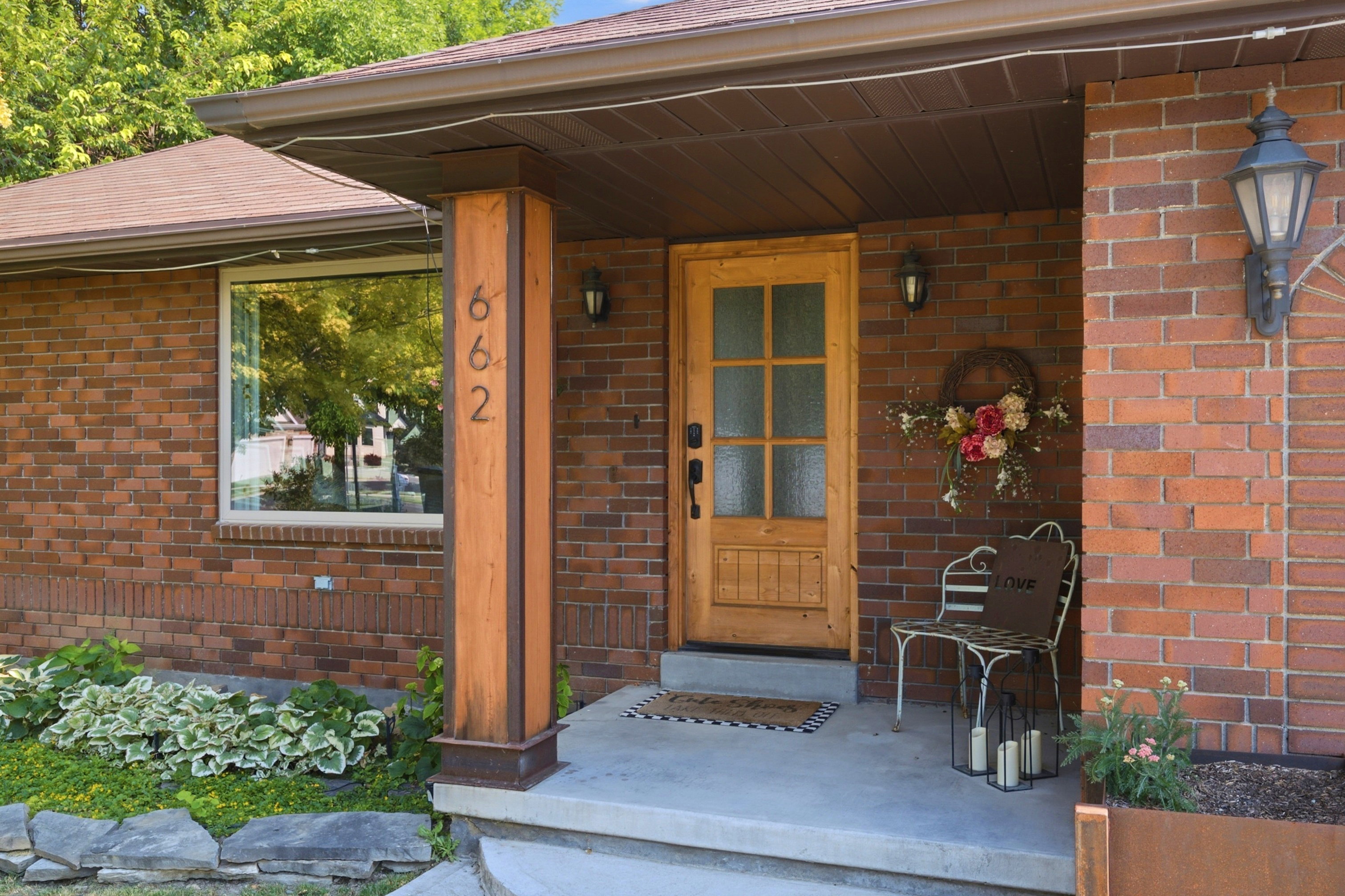 Brick exterior featuring a natural wood-finish front door with glass panels