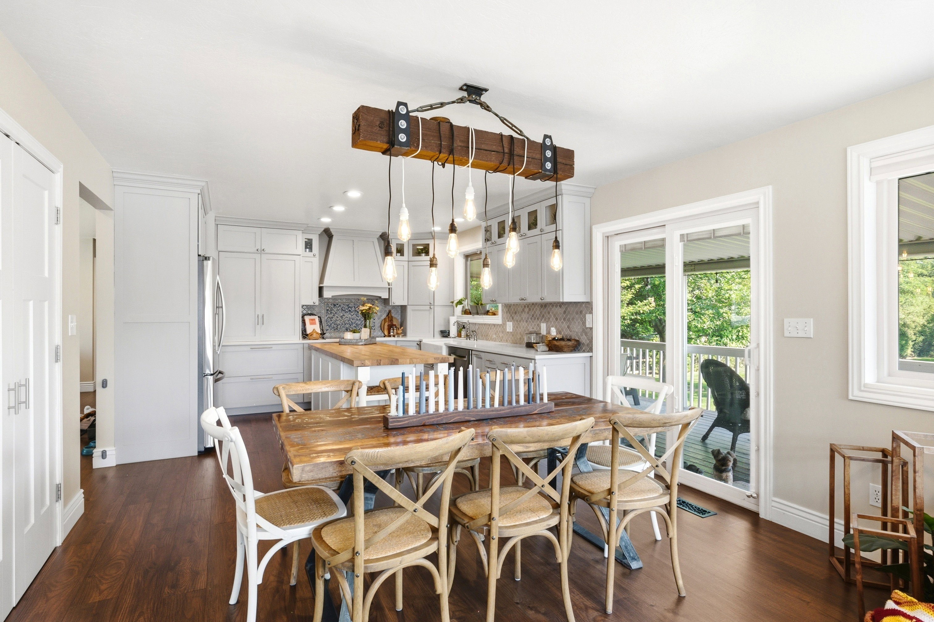 Open-concept dining area featuring wood-finish flooring and a distinctive suspended light fixture