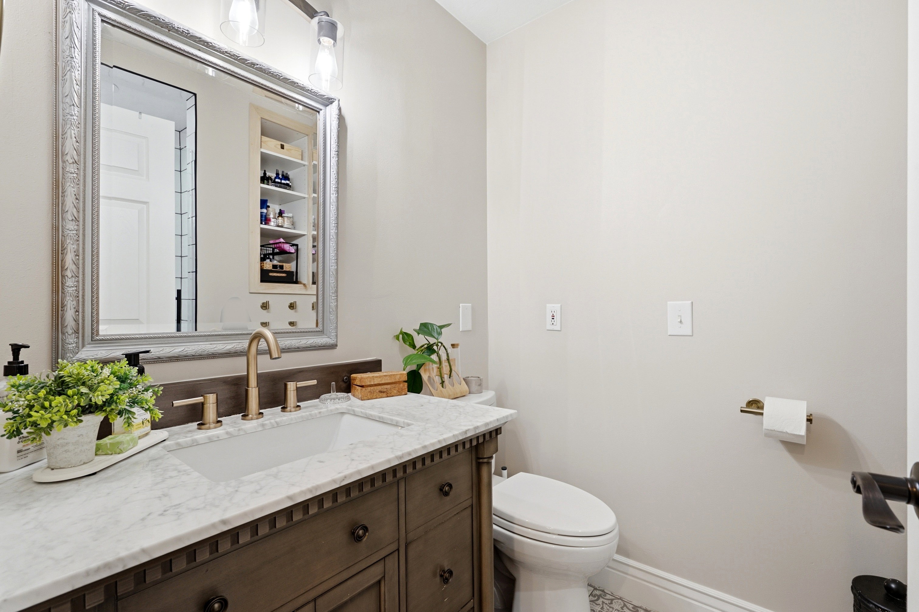 Vanity featuring an integrated sink, stone countertop, and gold-finish faucet