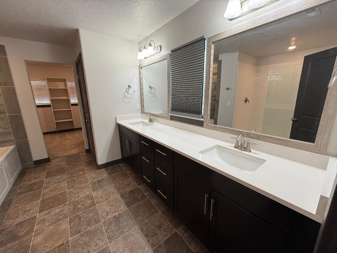 Double vanity with undermount sinks and white countertops in master bath