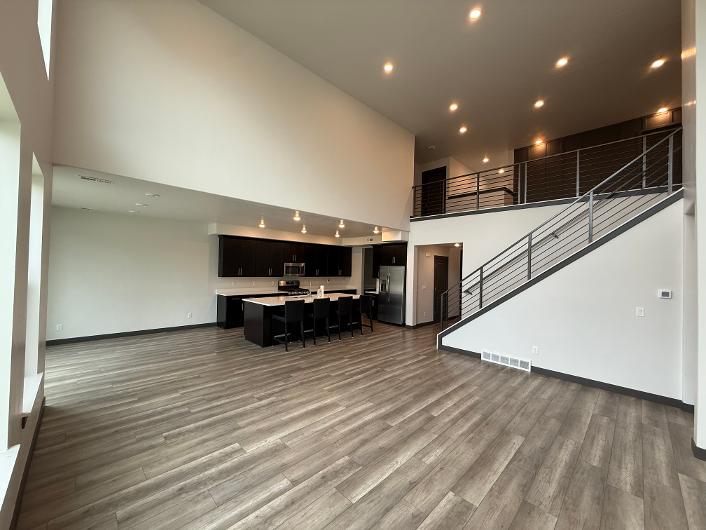 Open-concept main level featuring vaulted ceilings, wood-finish flooring, and recessed lighting