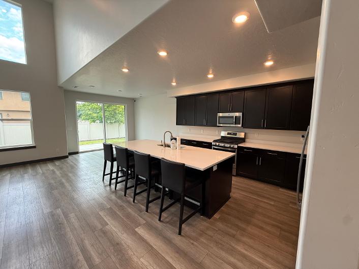 Open-concept kitchen and living area featuring wood-finish flooring