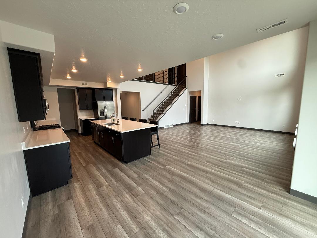 Open-concept great room featuring high ceilings and wood-finish flooring