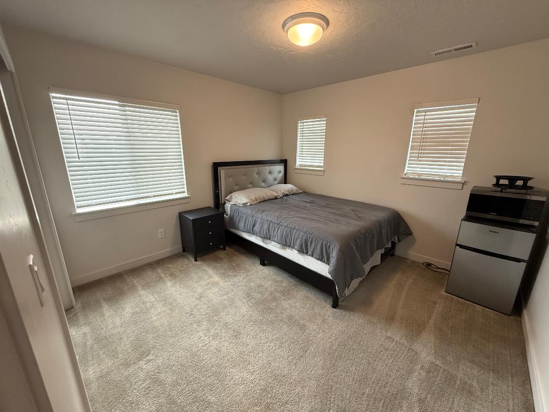 Neutral tone wall paint, plush carpet, recessed lighting, and multiple windows with blinds