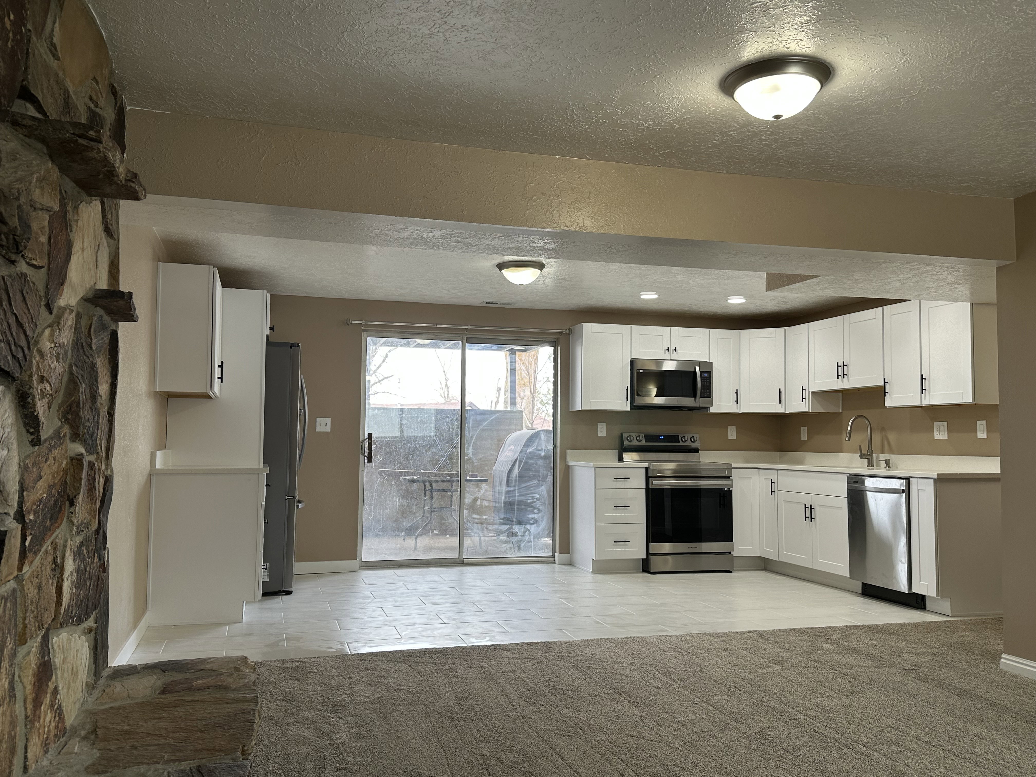 Modern kitchen featuring white cabinetry, stainless steel appliances, and light-toned countertops
