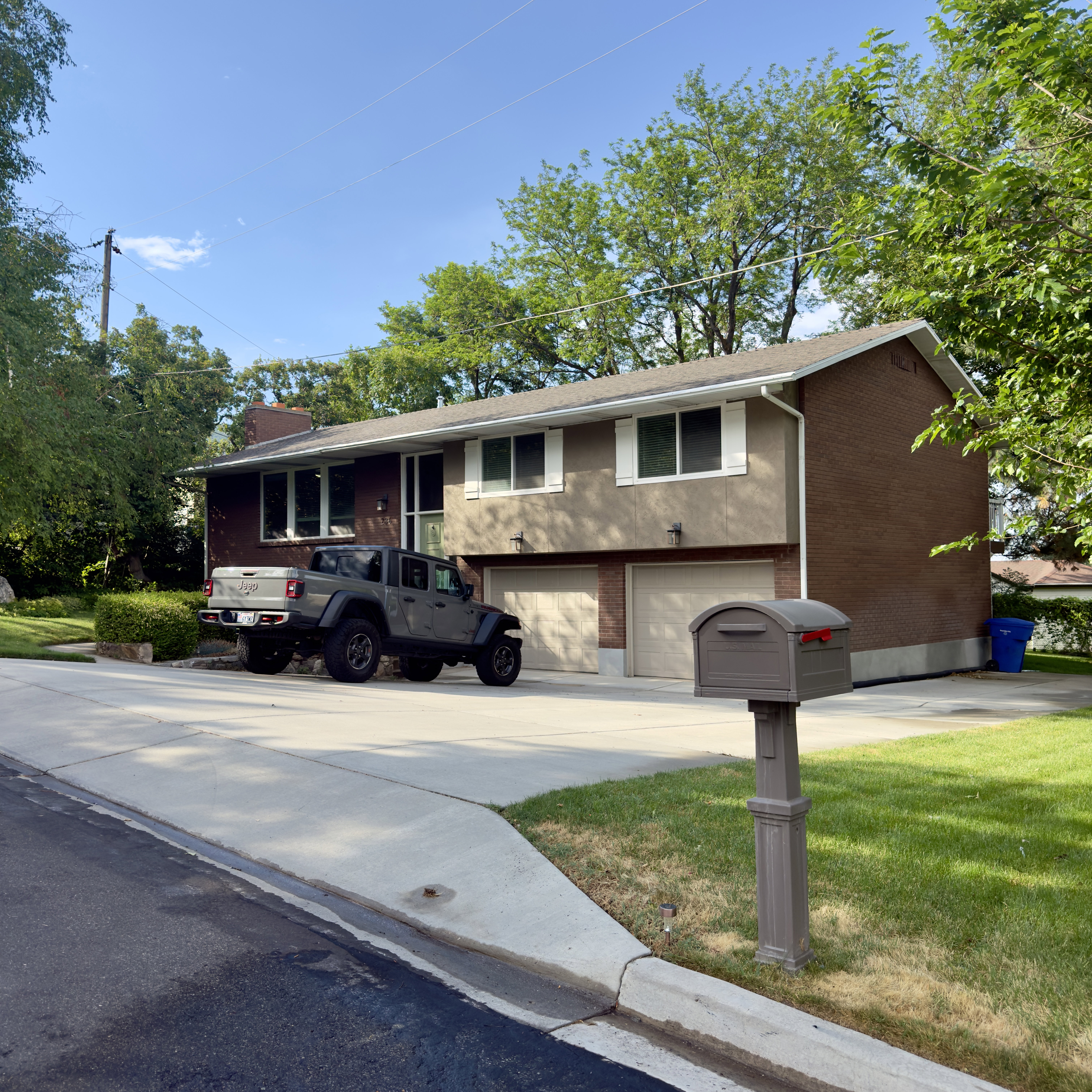 Two-story residence featuring a brick and stucco exterior, a two-car garage with individual doors, and a concrete driveway
