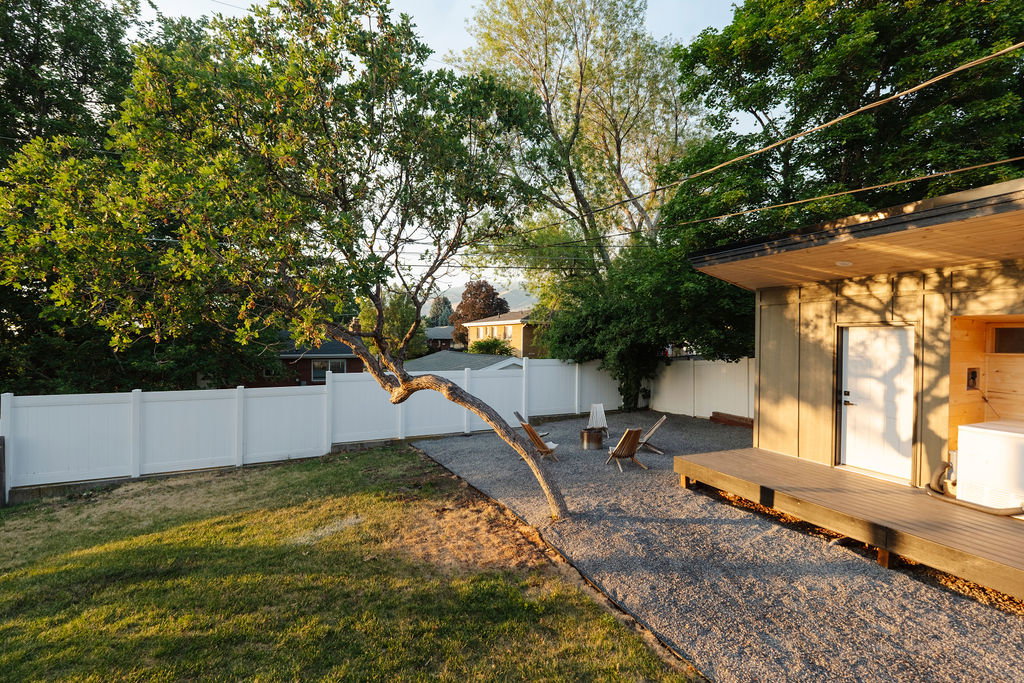 Outdoor living area featuring a wood-finish deck, gravel patio, and a privacy fence