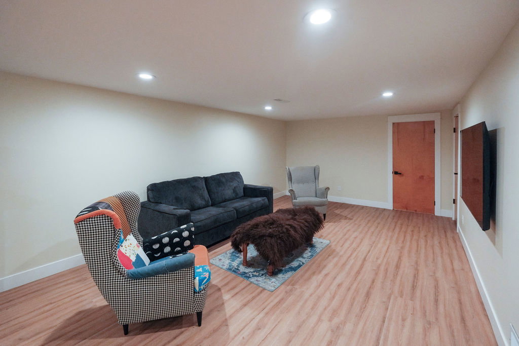 Spacious room featuring wood-finish flooring, recessed lighting, light-toned walls, and white baseboards