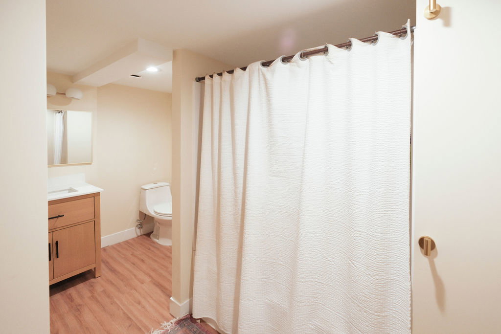 Bathroom featuring wood-finish flooring, a contemporary vanity with a white countertop, and a recessed ceiling light