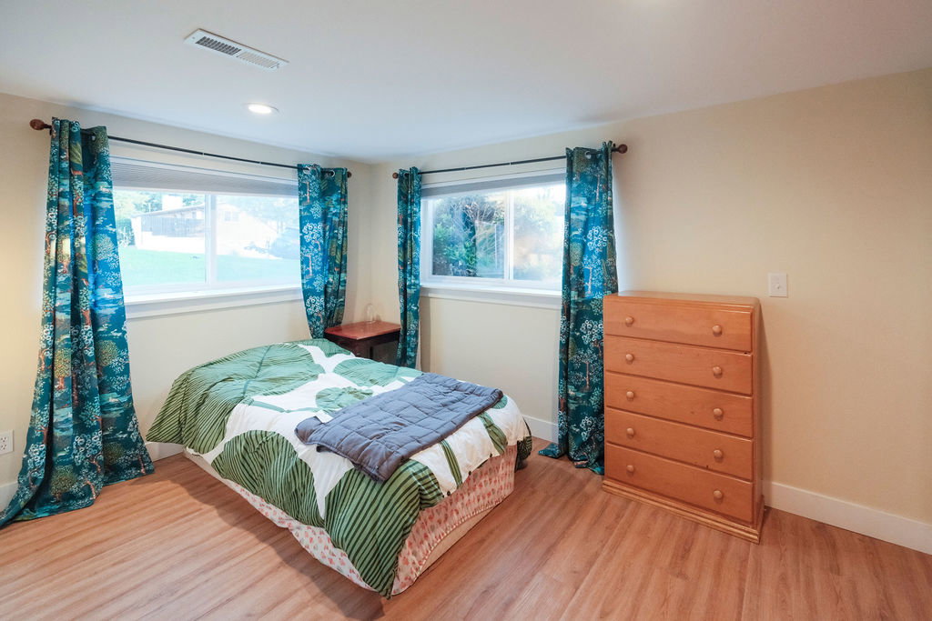 Bedroom featuring wood-finish flooring, recessed lighting, and two large windows