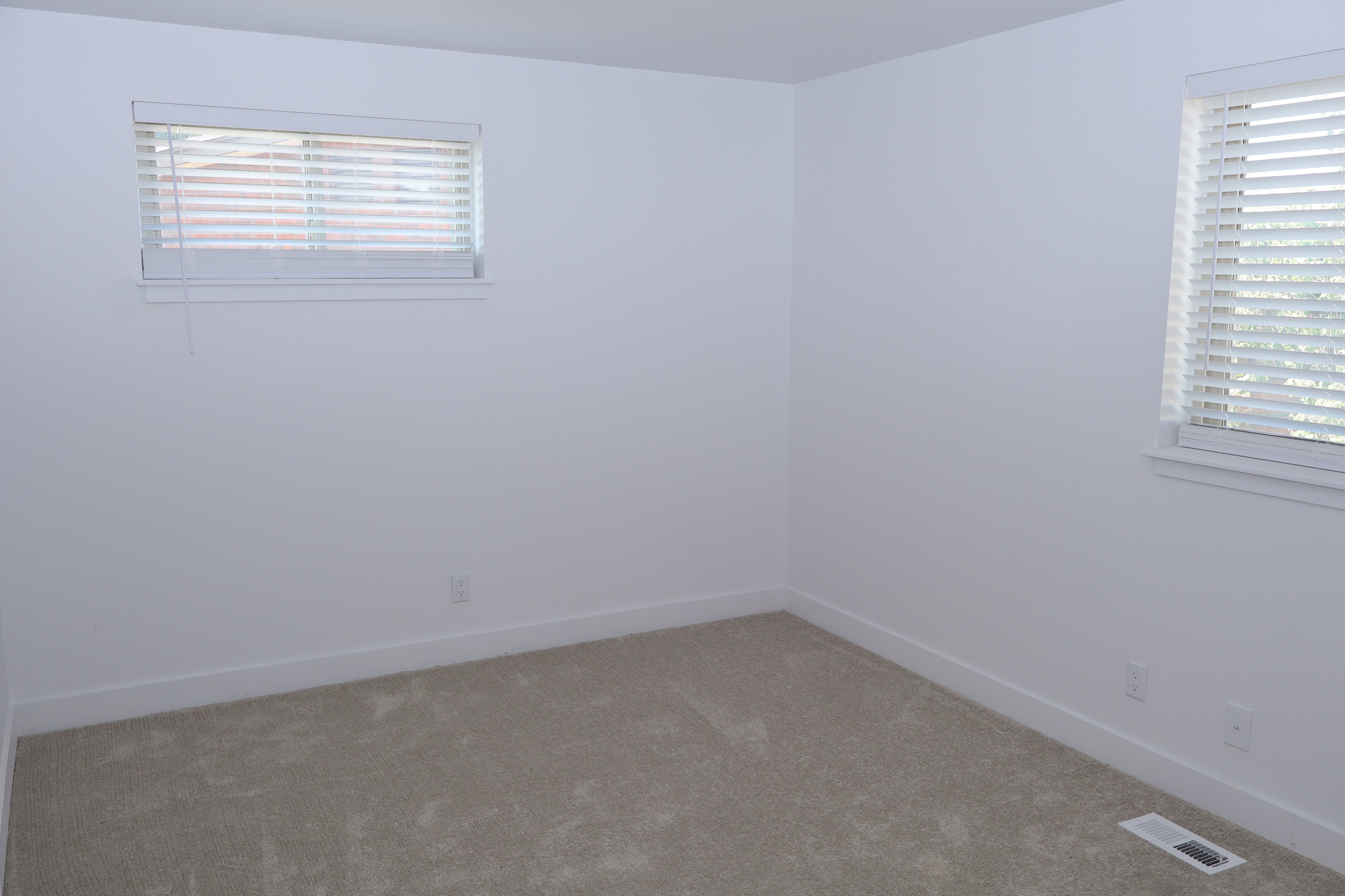 Neutral-toned wall-to-wall carpeting complements the bright white walls and trim