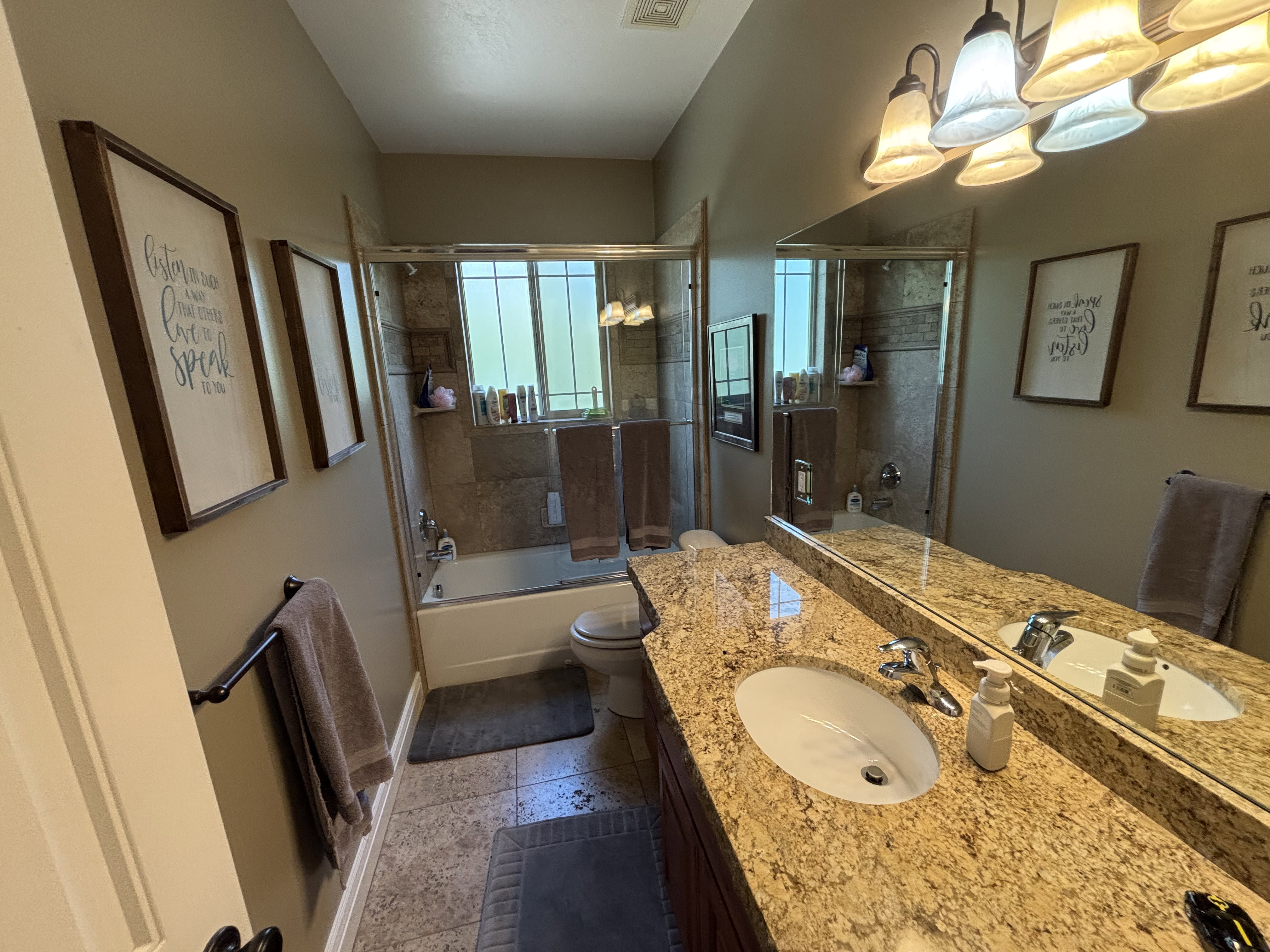 Bathroom vanity with an integrated oval sink and a polished chrome faucet set on a speckled countertop