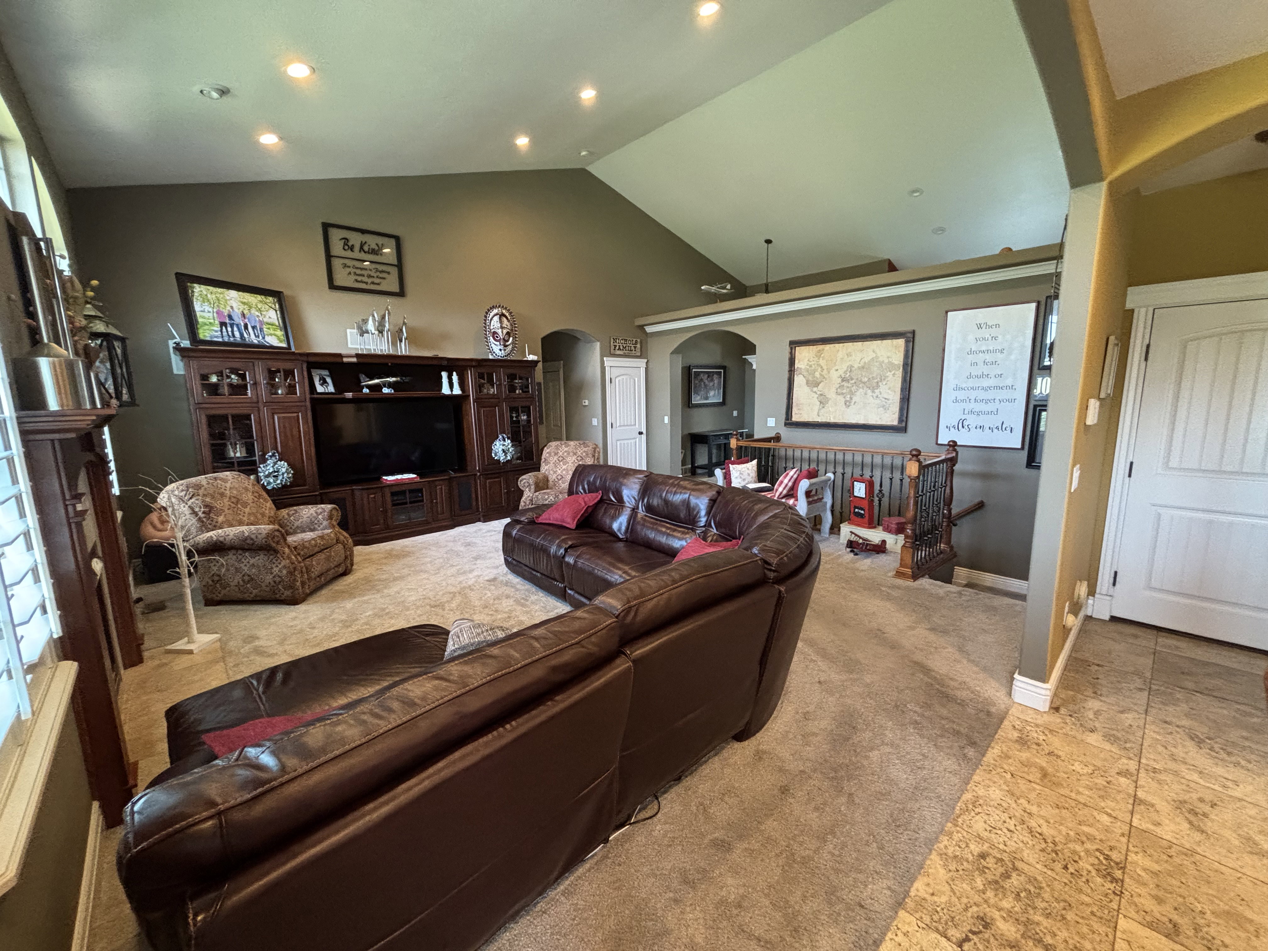 Open-concept living space with a vaulted ceiling and recessed lighting