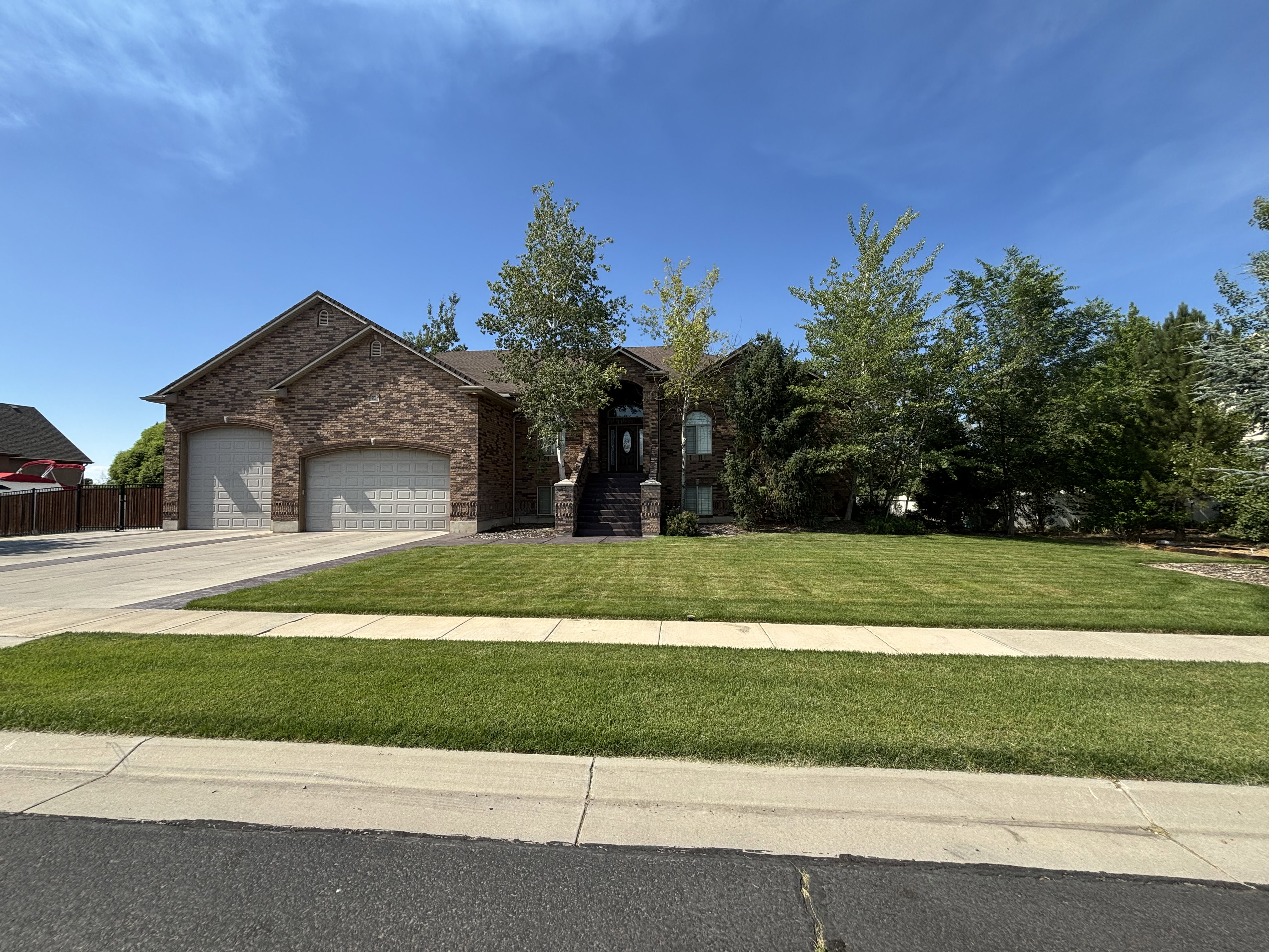 Brick-front residence with a two-car garage featuring arched doors