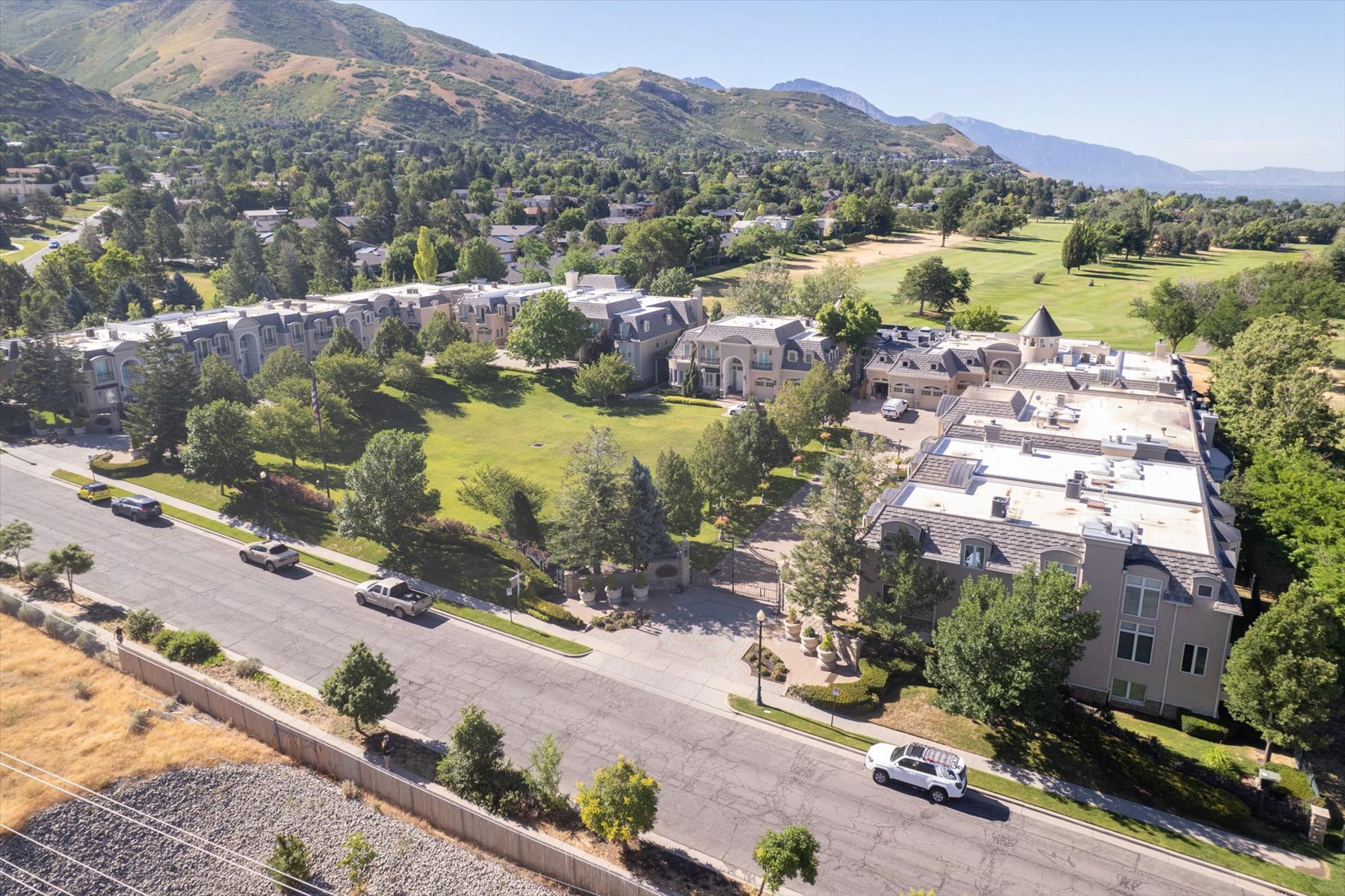 Aerial view showcasing multiple residential buildings, a manicured green space, and a golf course
