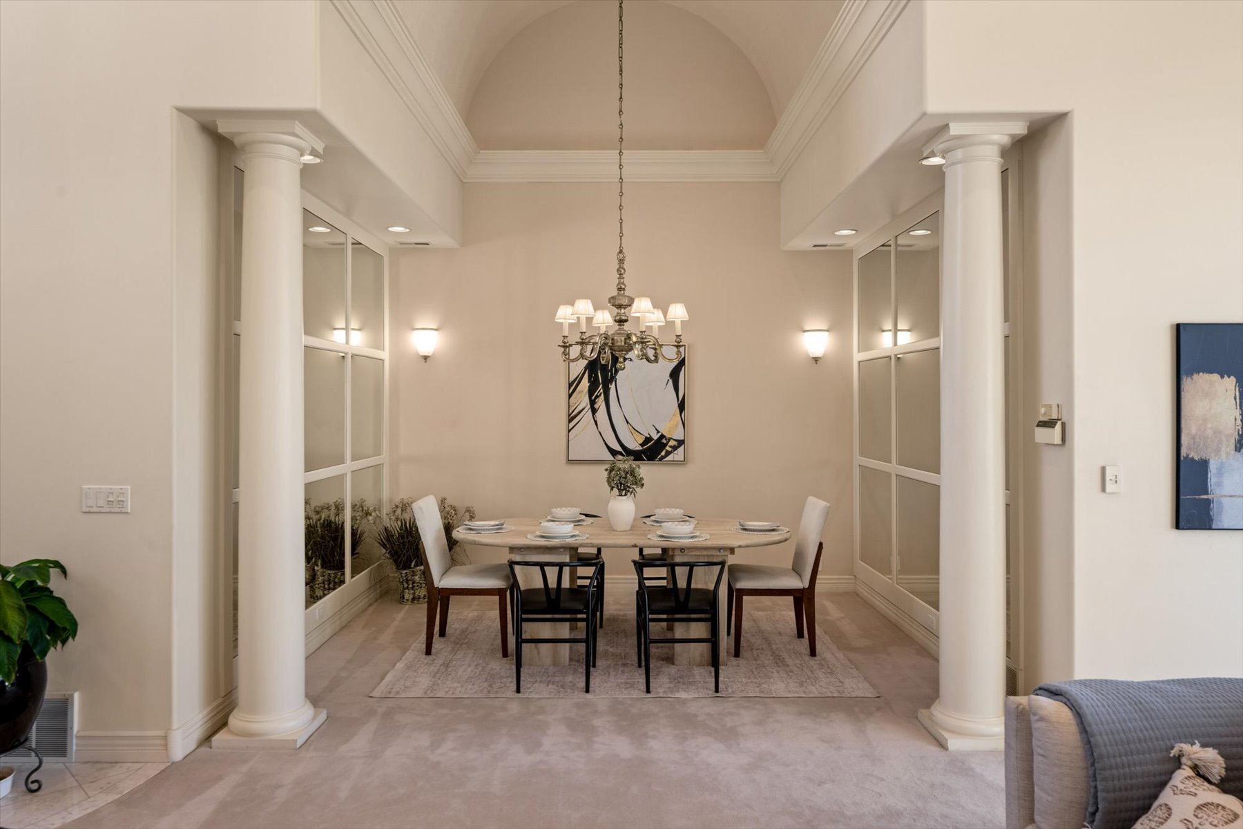 Formal dining area featuring architectural columns, an arched ceiling, recessed lighting, wall sconces, and a chandelier