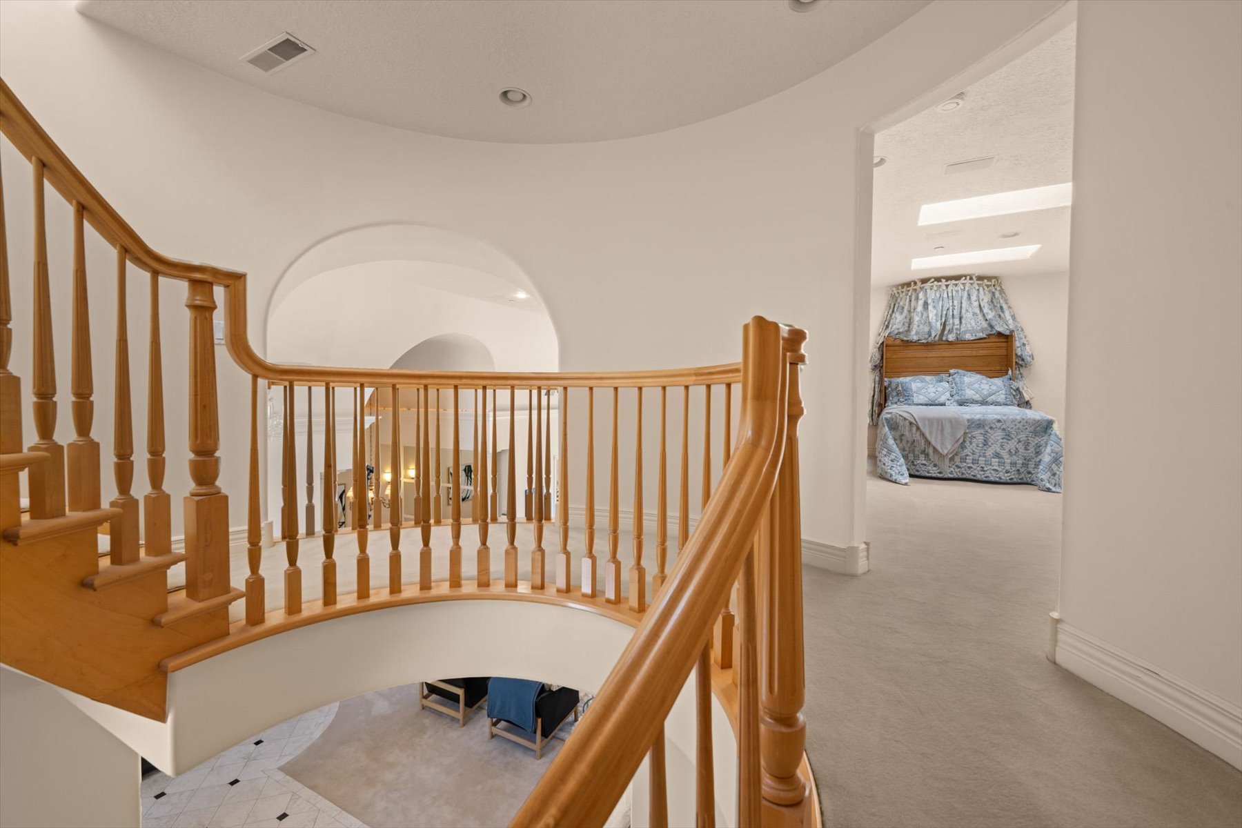 Curved natural wood staircase with balusters and handrail