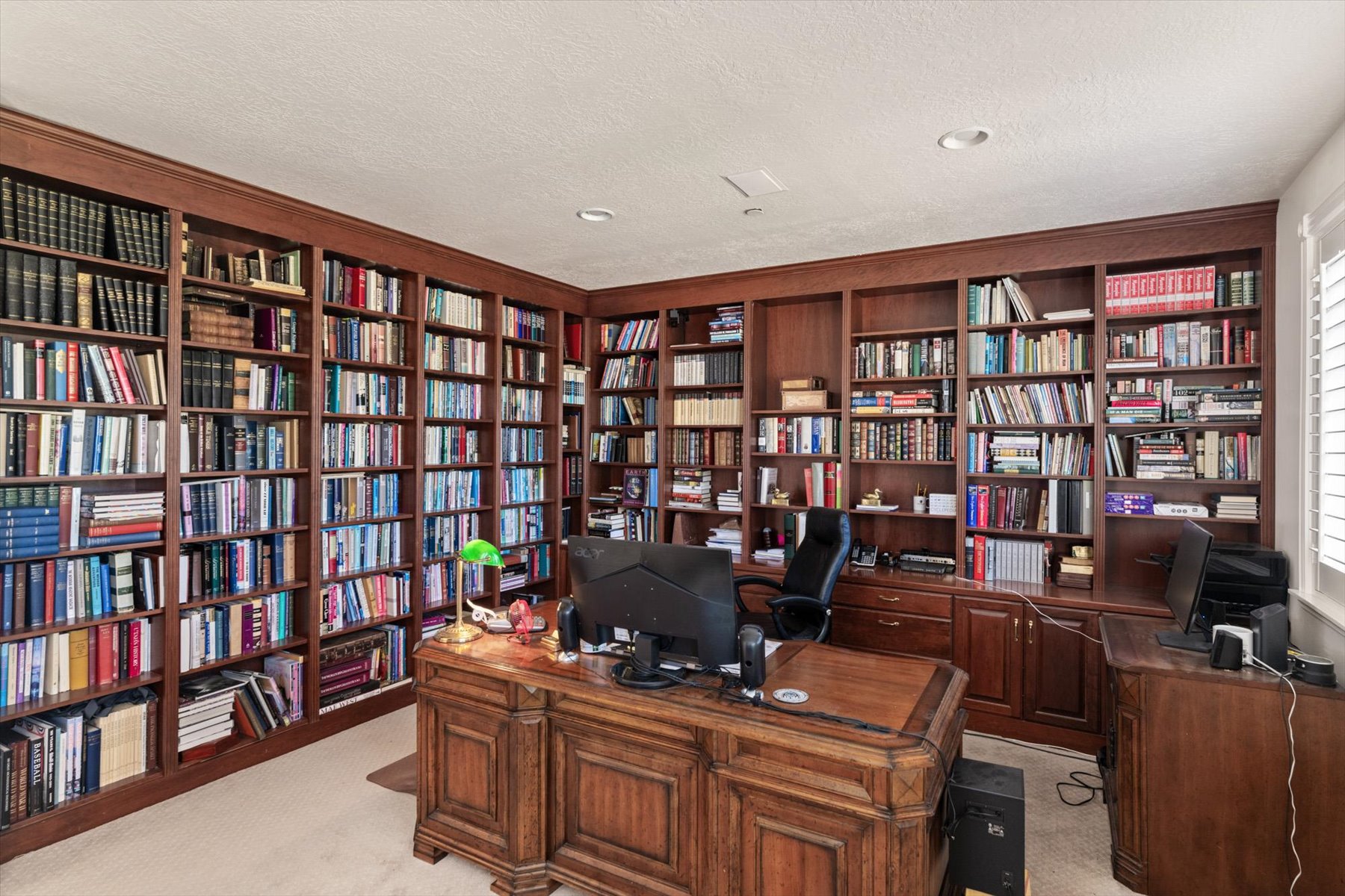Extensive built-in wood cabinetry lines the walls, offering comprehensive storage and display capabilities, could also be bedroom