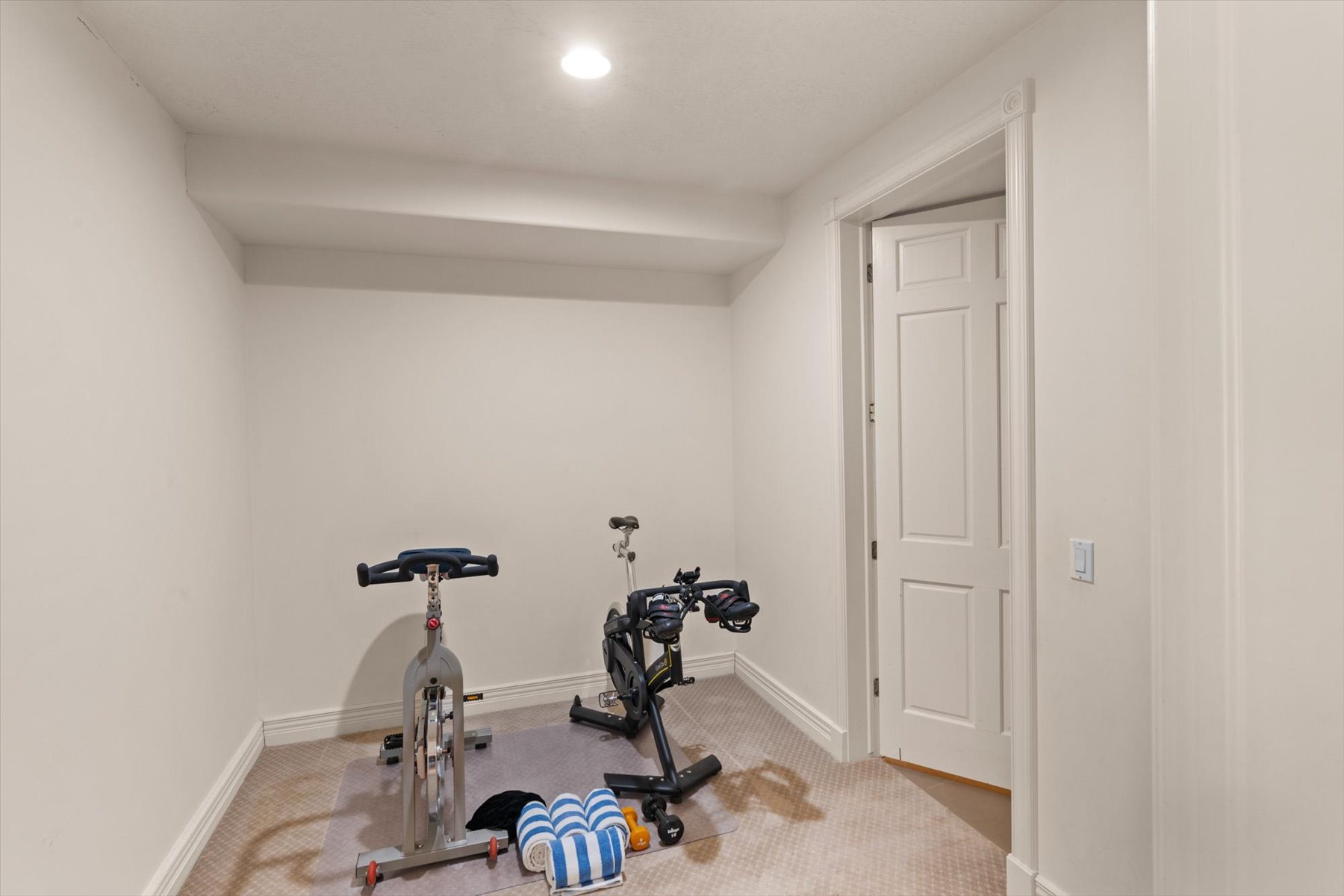 Carpeted room with recessed lighting and a single panel interior door