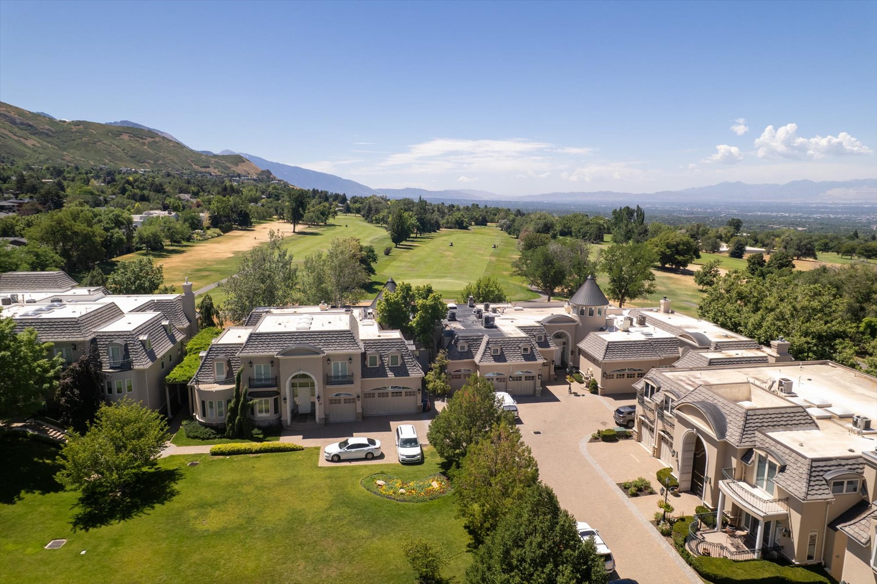 Expansive property featuring a meticulously manicured lawn, paved driveway, and traditional architectural styling