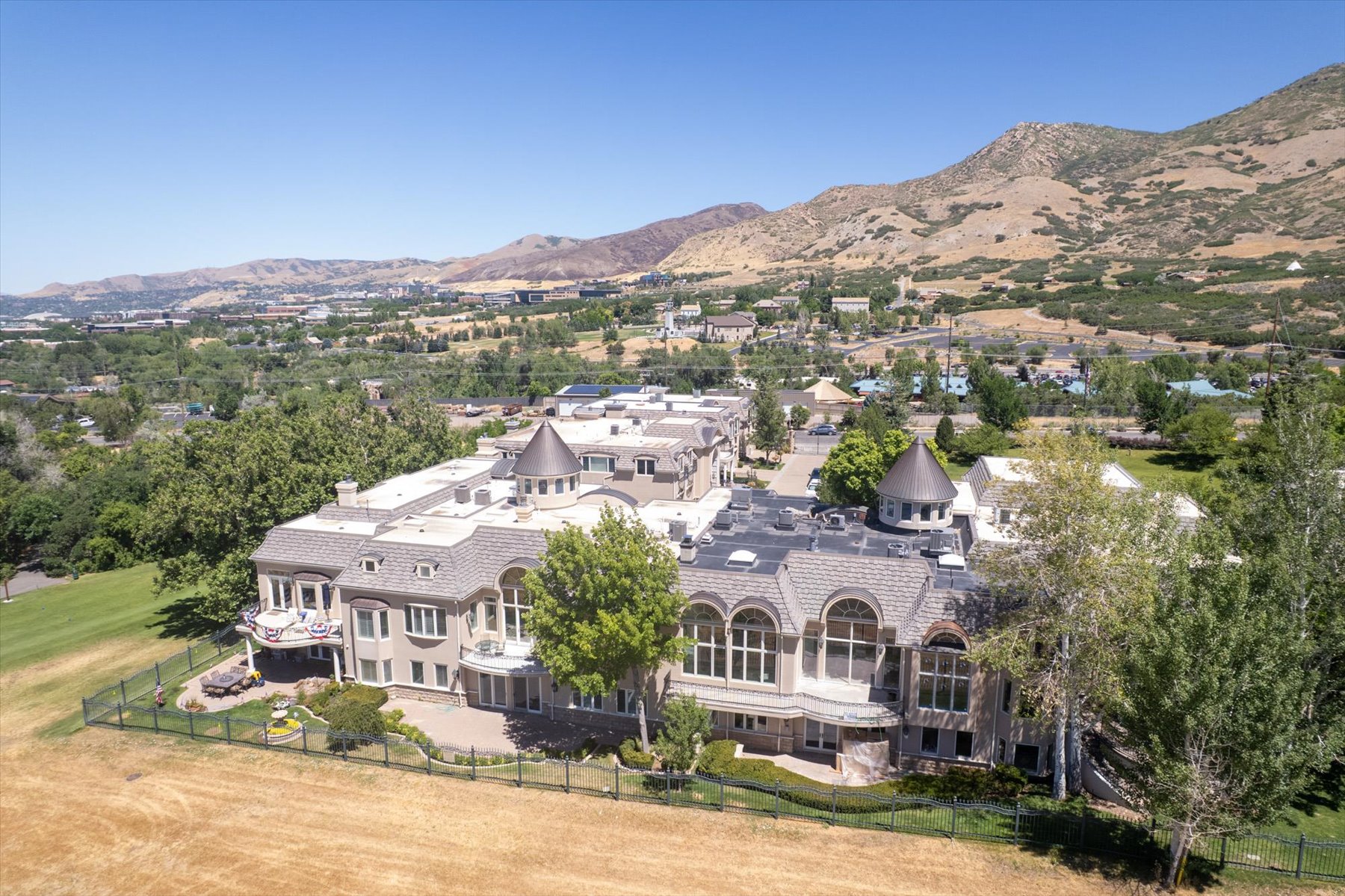 Expansive property featuring multiple structures with distinctive turret roofs and arched window designs