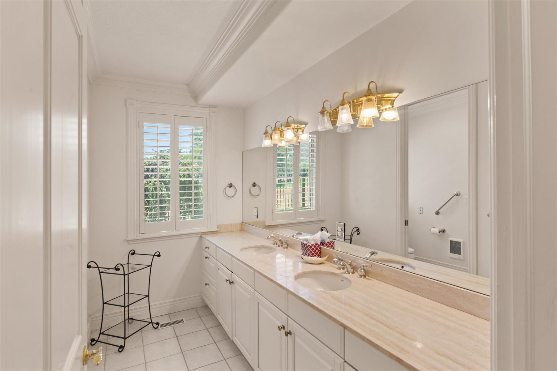 Expansive vanity with dual undermount sinks, a stone countertop and a shower