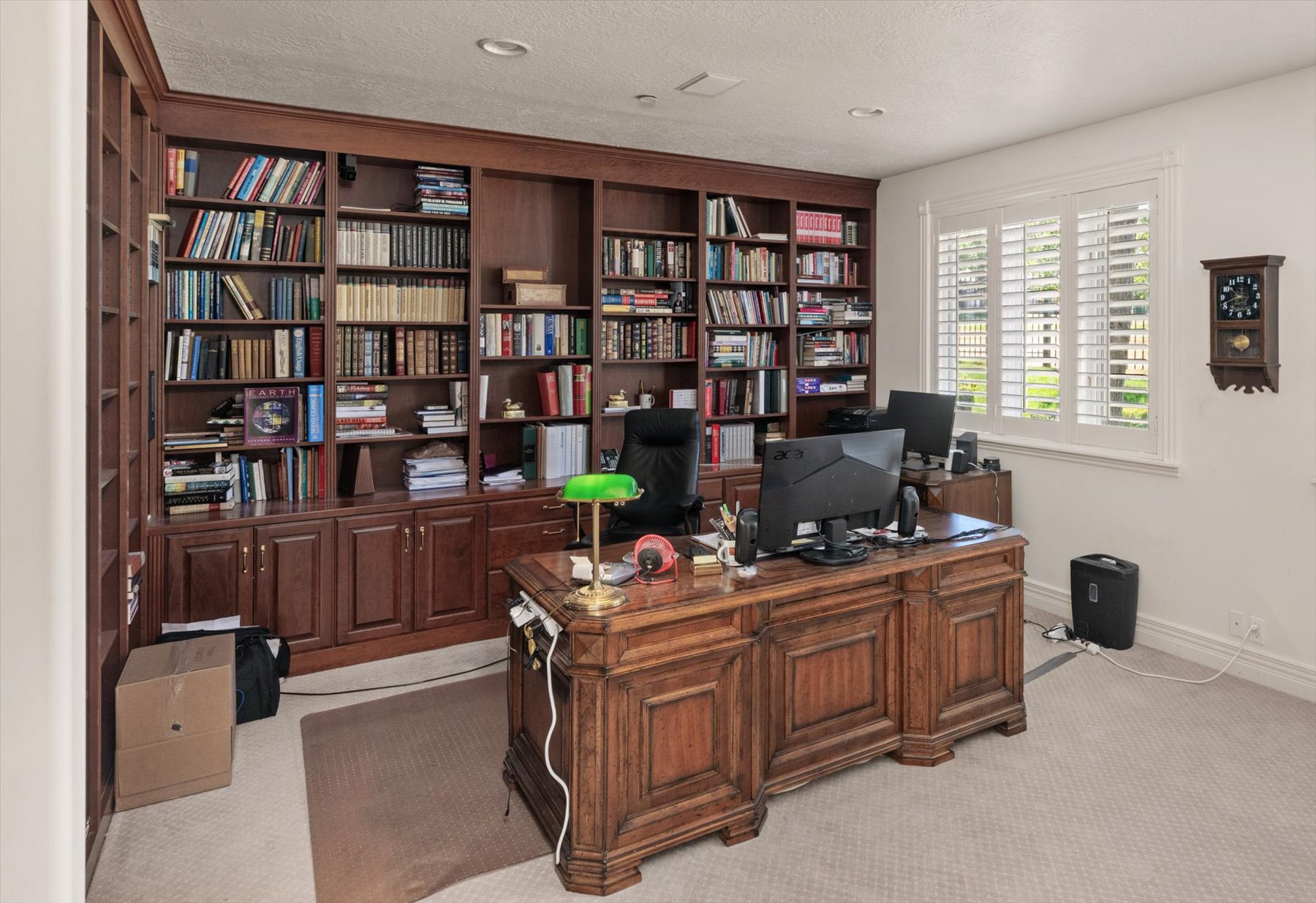 Dedicated office space featuring extensive built-in wood cabinetry and shelving, or bedroom