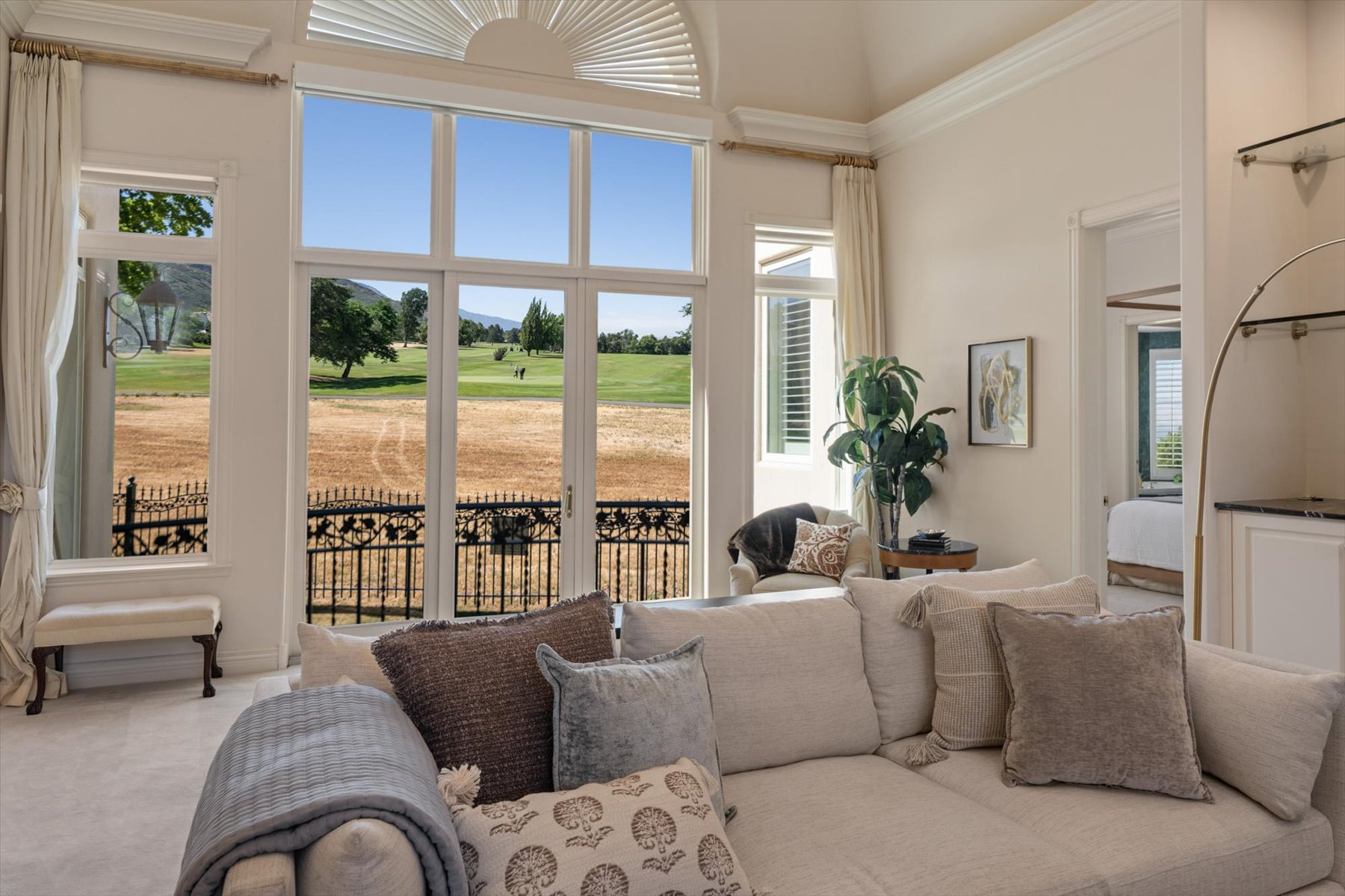 Spacious interior with vaulted ceilings and expansive windows looking out at 13th green at Bonneville Golf Course!