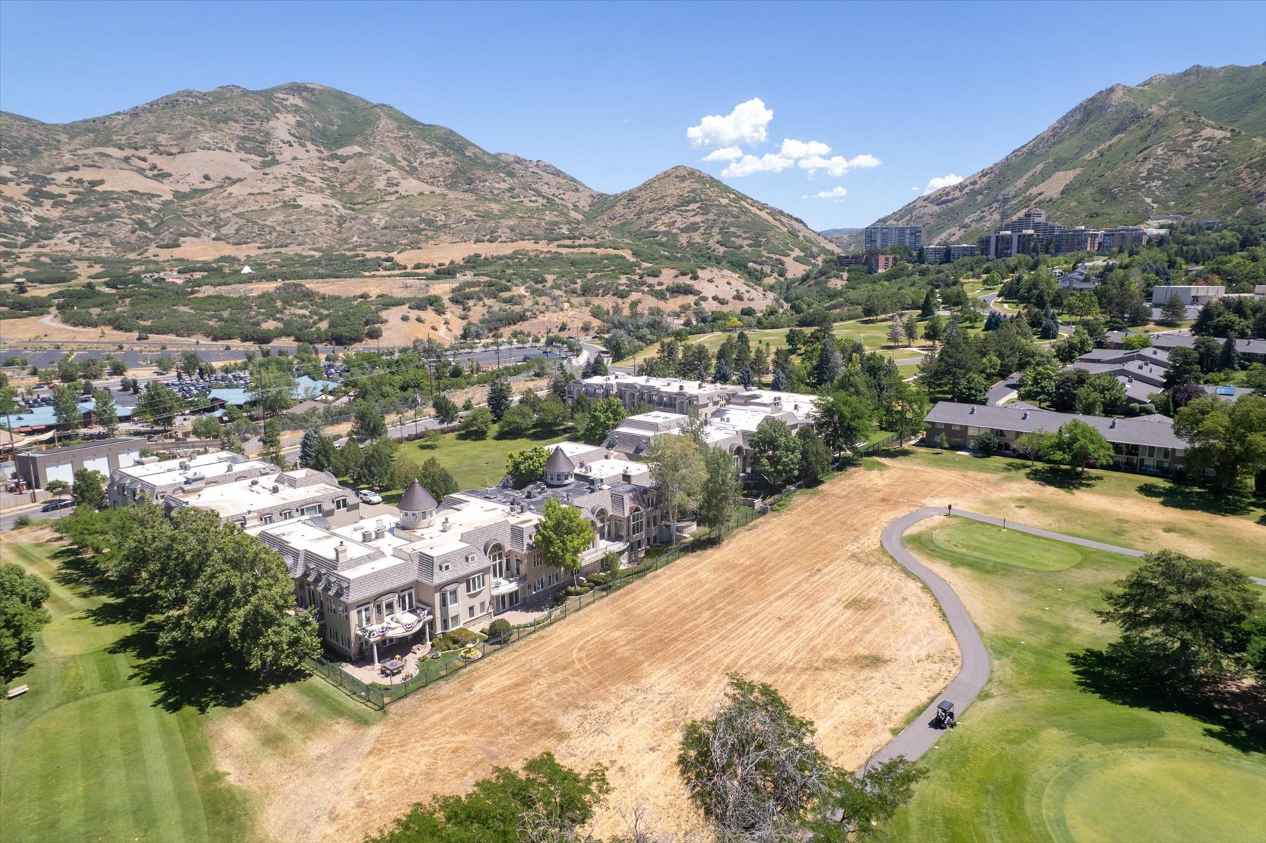 Expansive property featuring a prominent multi-story residence with a turret, multiple balconies, and a complex roofline