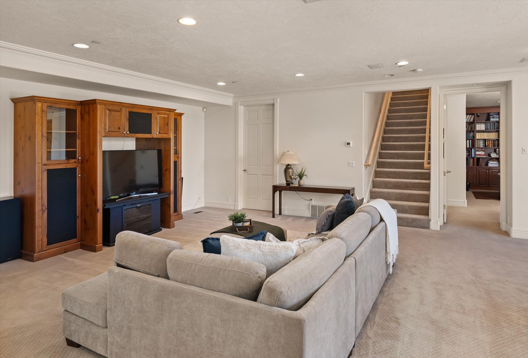 Spacious living area featuring neutral carpeting and recessed lighting