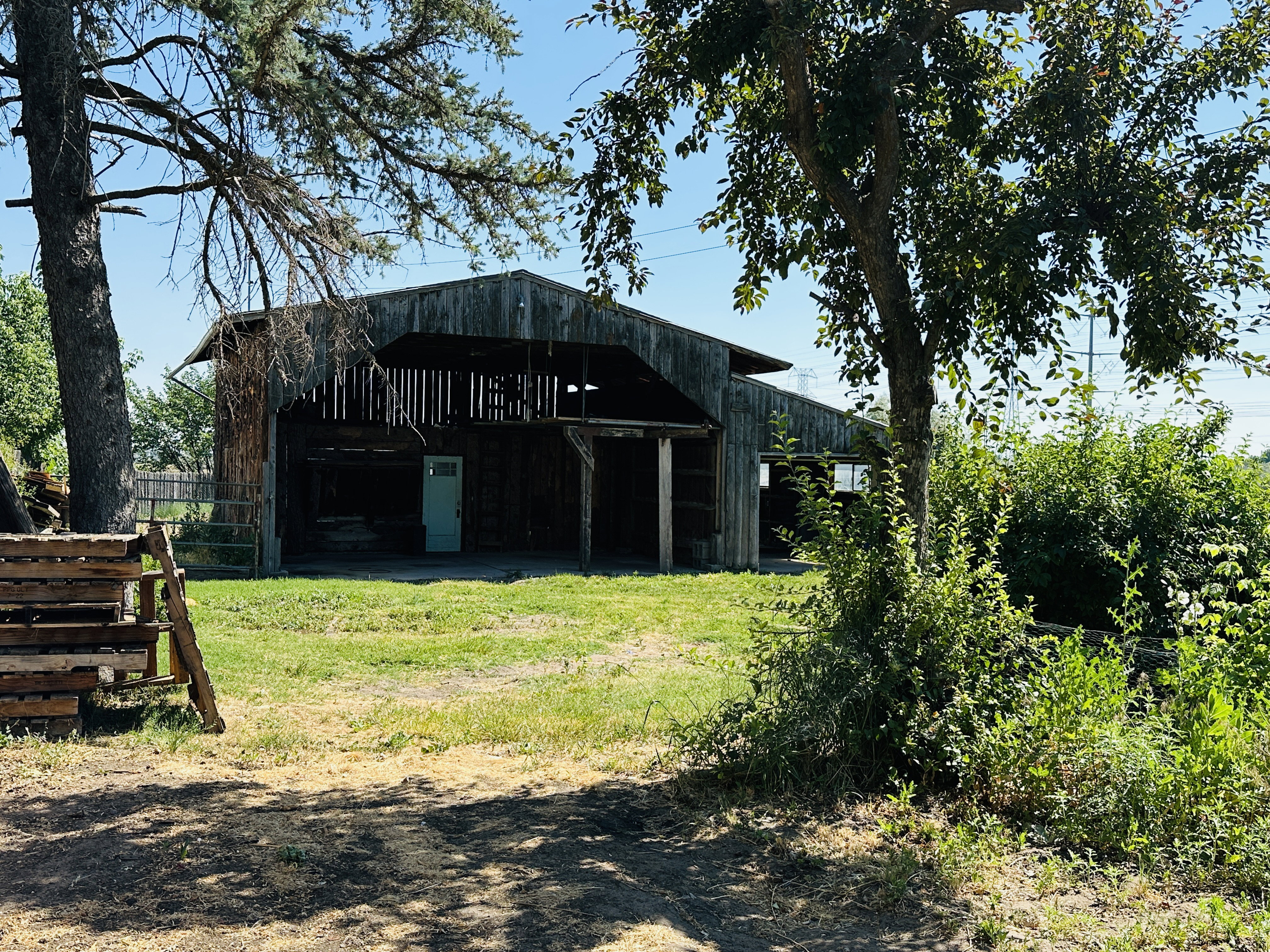 Rustic wood barn structure featuring a gabled roof and a light blue entry door