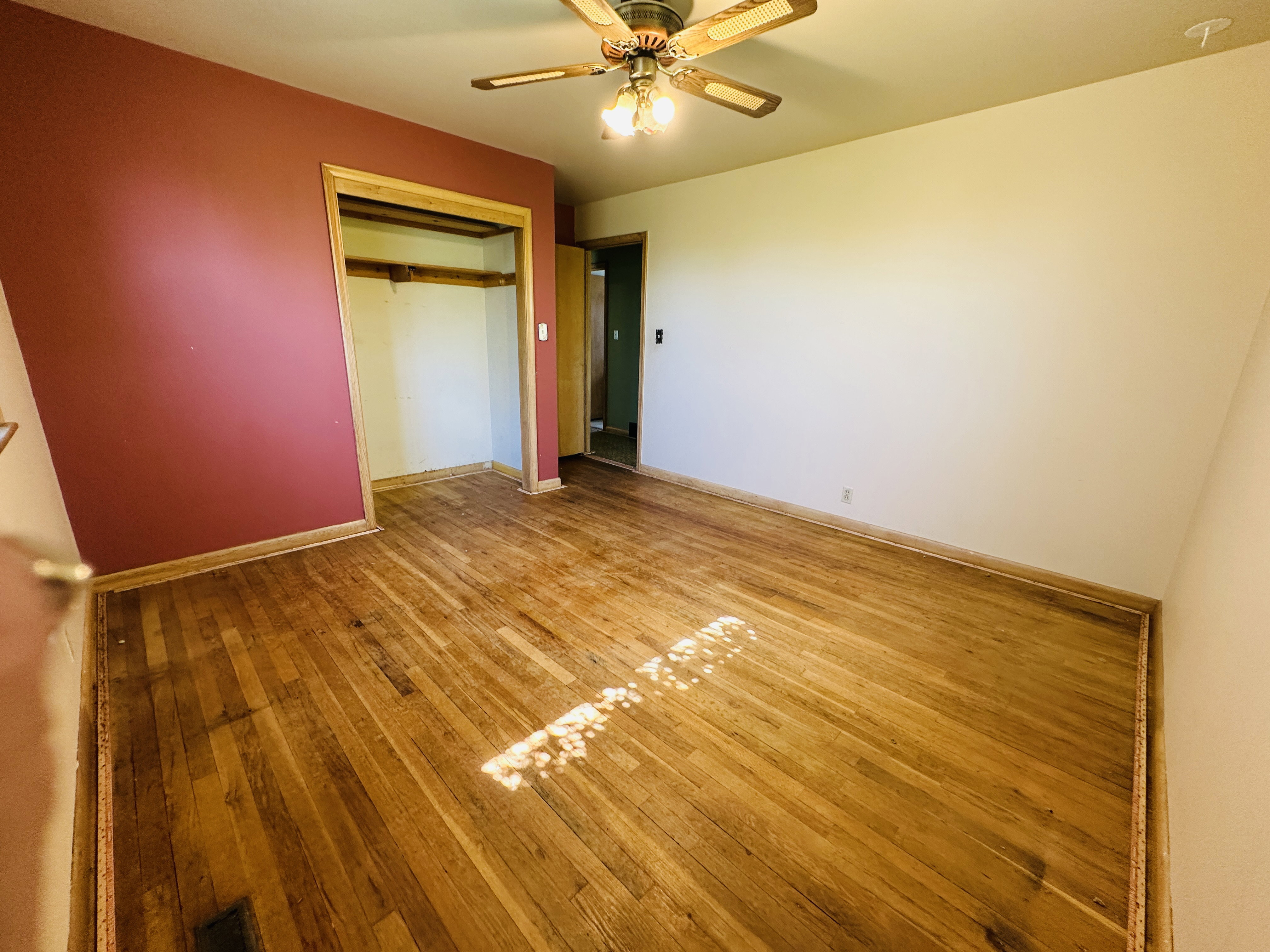 Hardwood flooring throughout, featuring a ceiling fan with light fixture