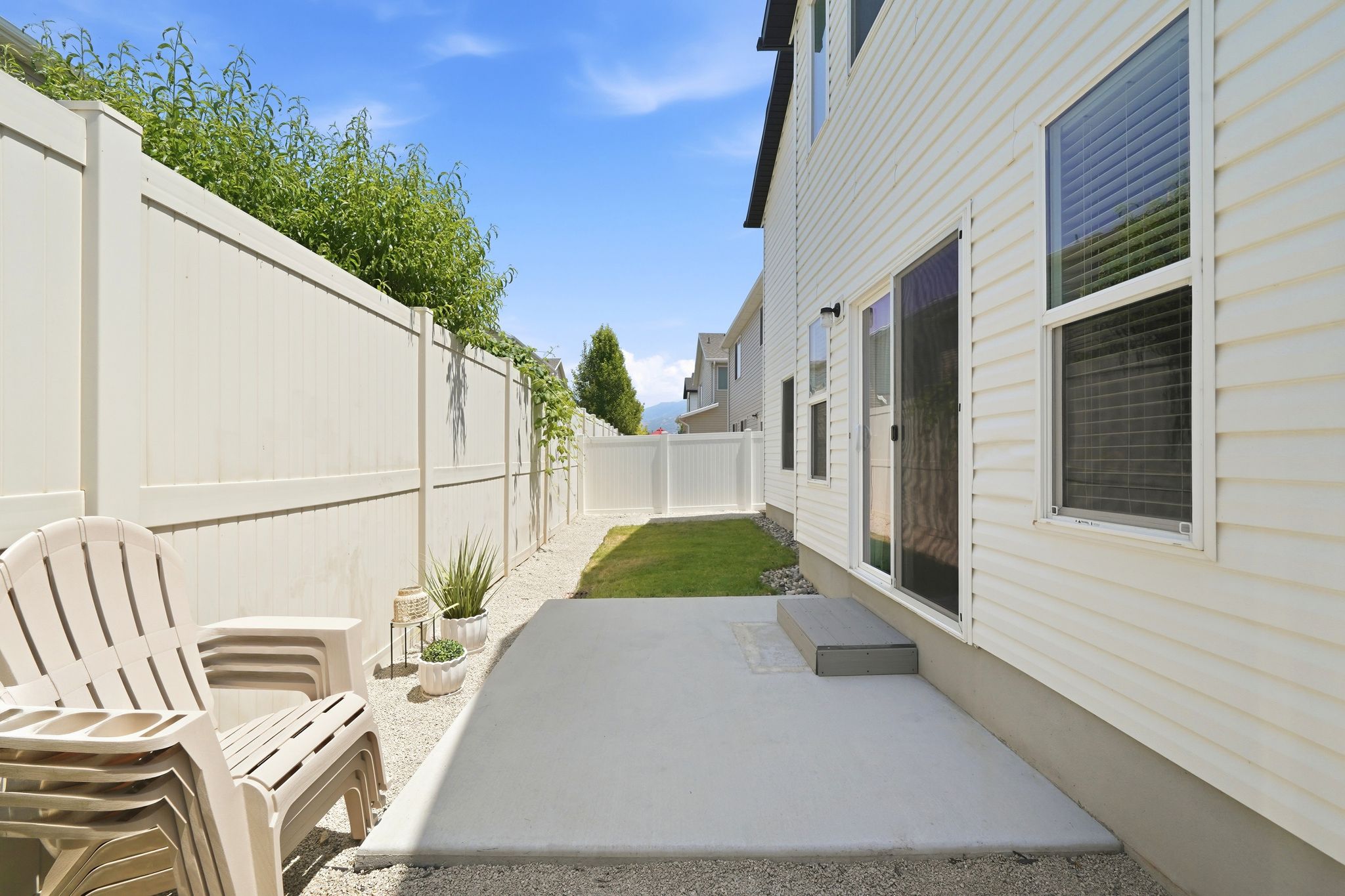 Private outdoor space featuring a concrete patio, gravel border, and a strip of green lawn