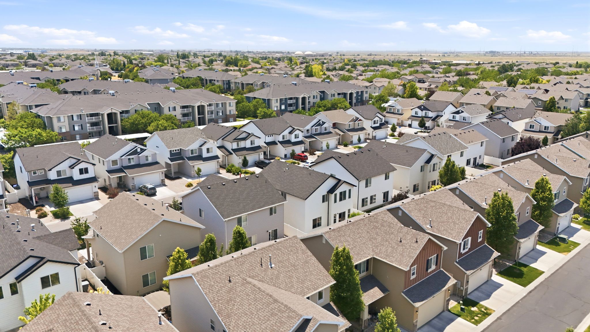 Aerial perspective showcasing a residential development featuring single-family homes and multi-story apartment buildings