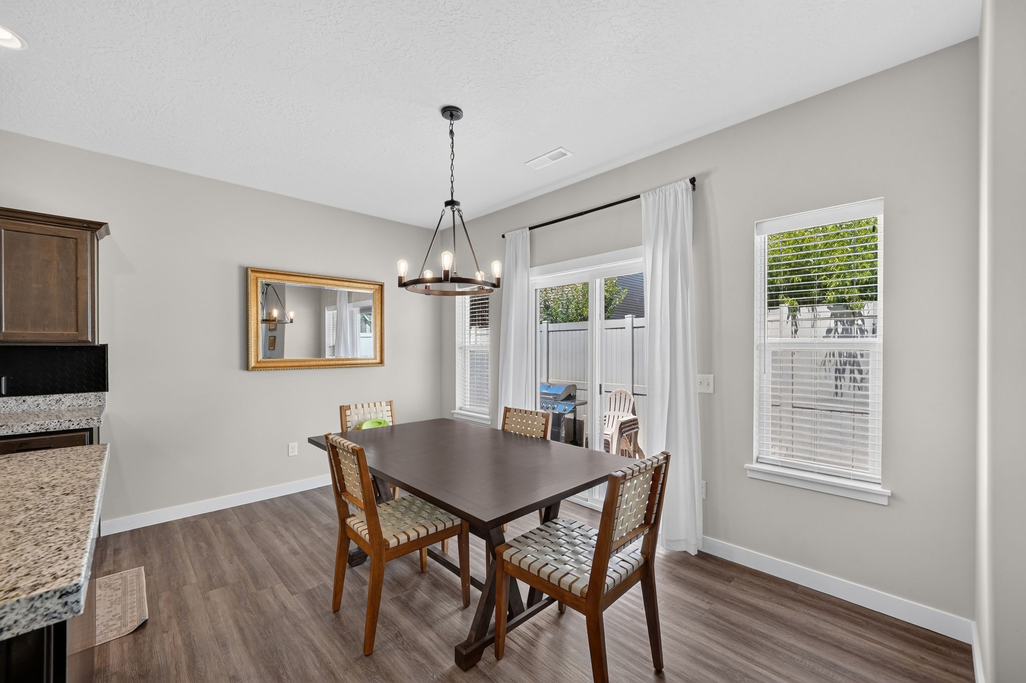 Dining area featuring wood-finish flooring, a contemporary chandelier, and light gray wall paint