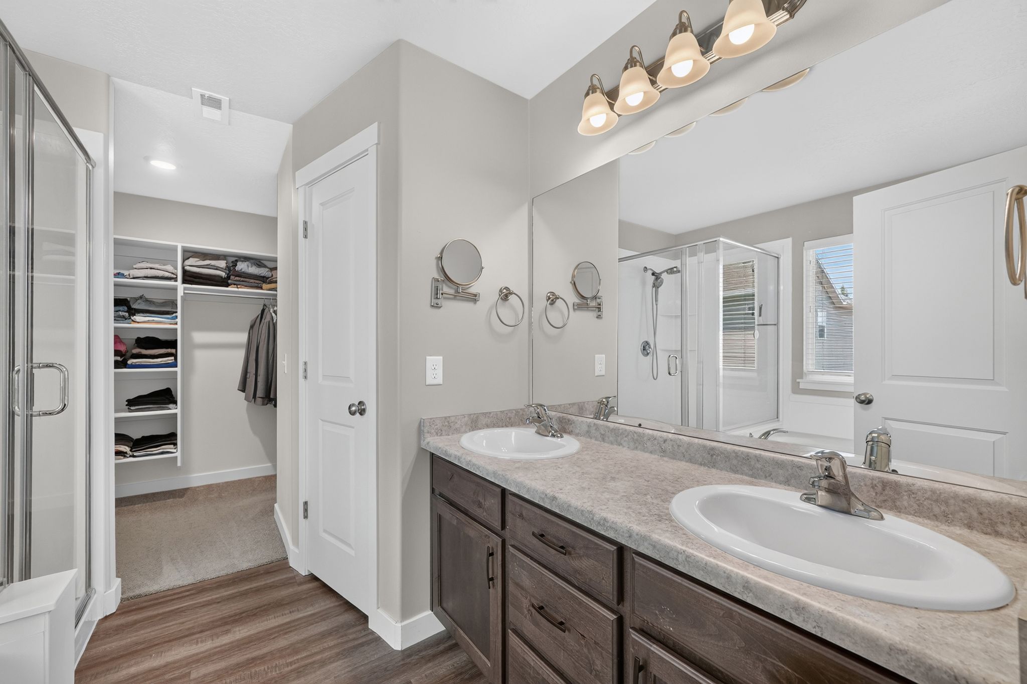 Spacious bathroom featuring a dual vanity with wood-finish cabinetry and a large mirror