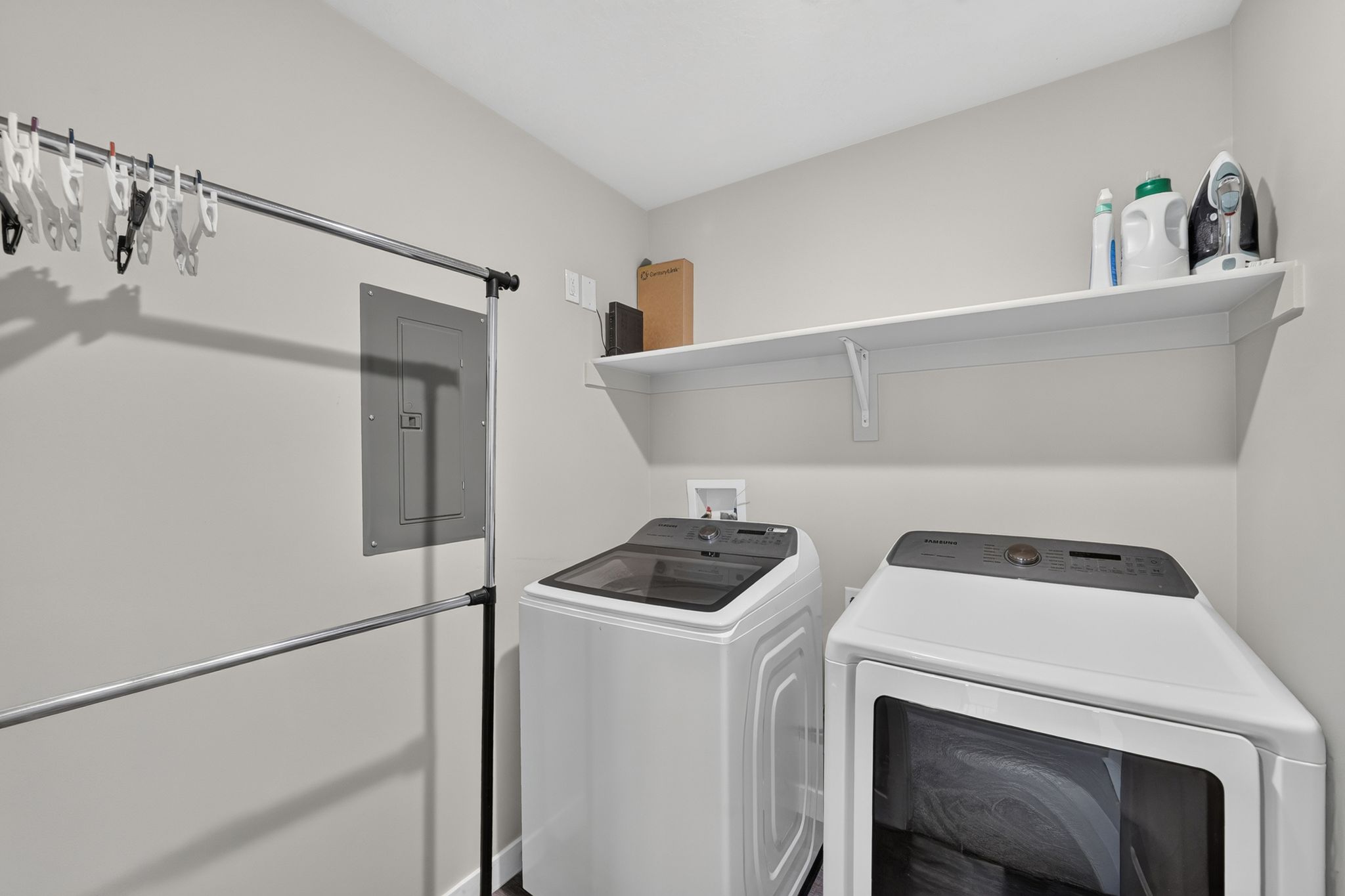Dedicated laundry area featuring a wall-mounted shelf, electrical panel, and hookups for appliances