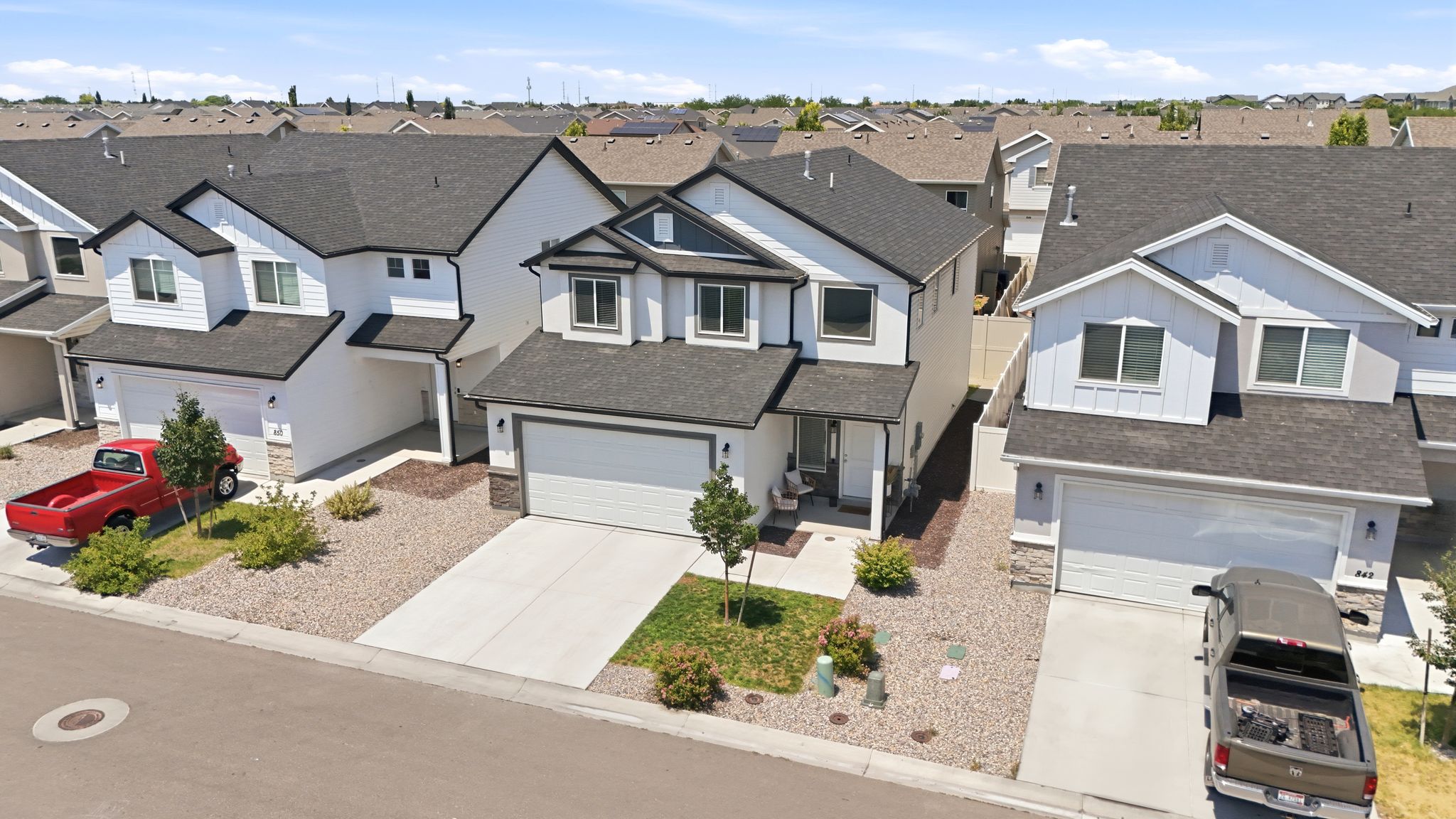 Modern two-story exterior featuring white siding and dark trim accents
