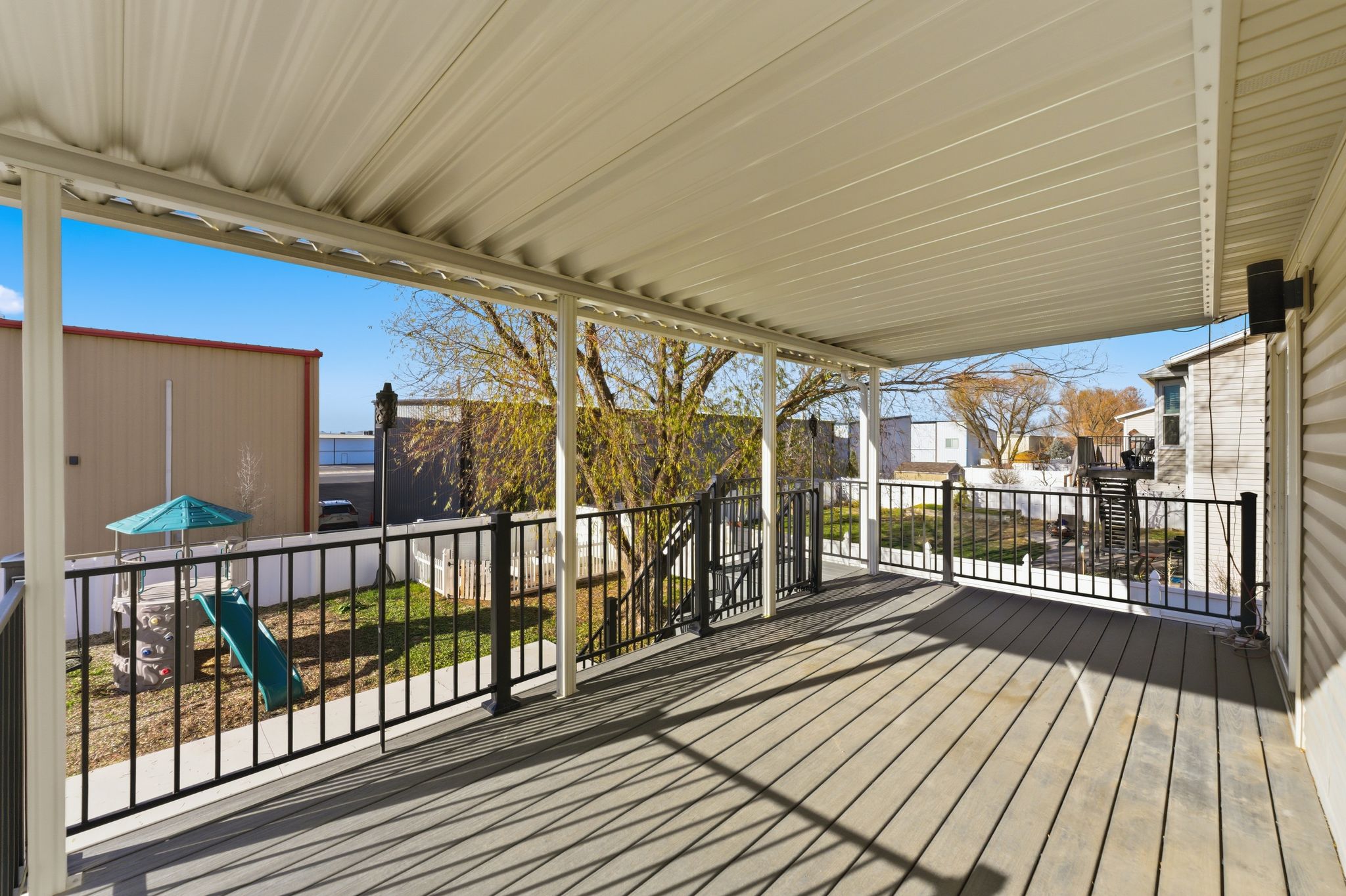 Expansive covered deck featuring composite decking and a white metal roof
