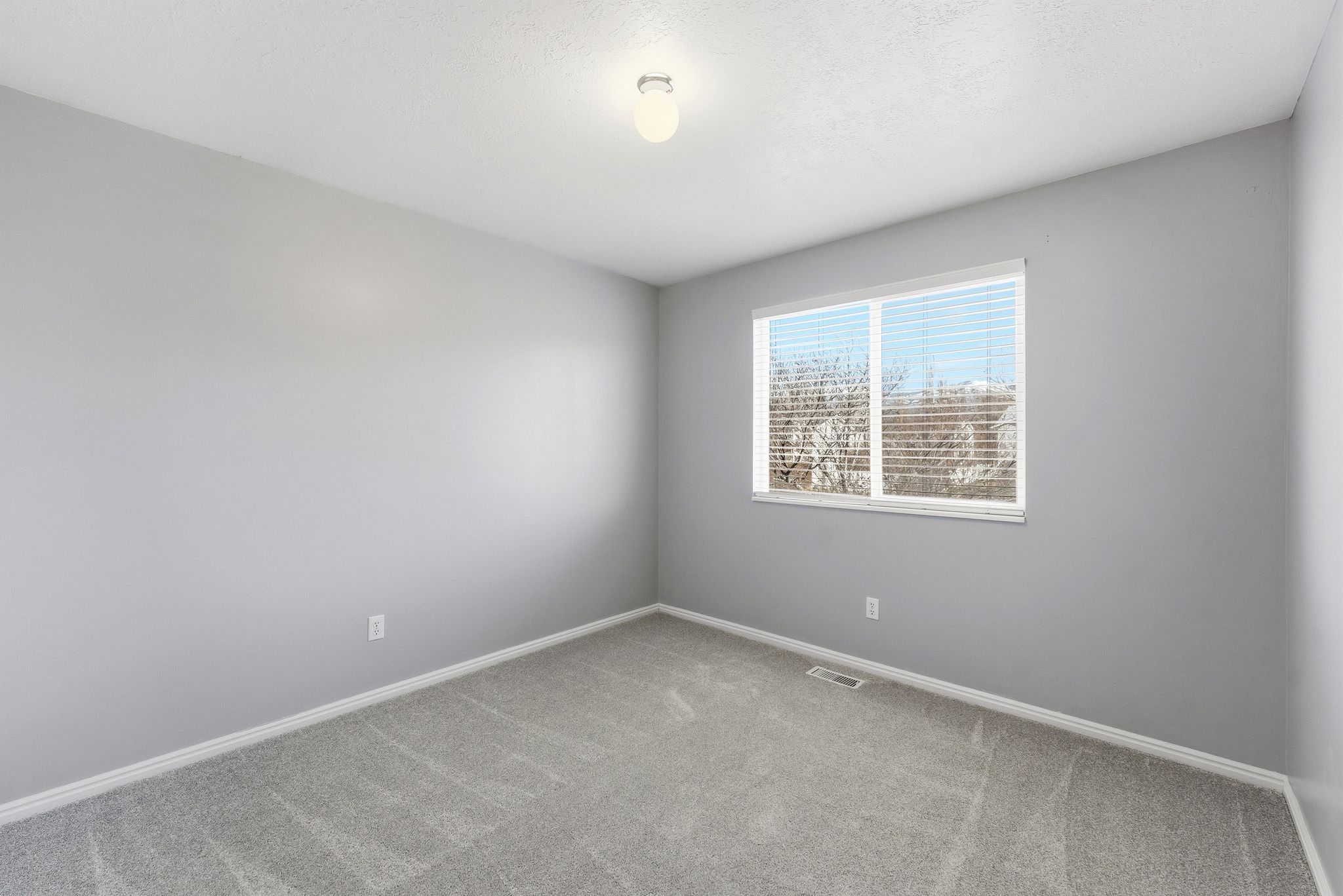 Room featuring neutral gray walls and gray carpet flooring