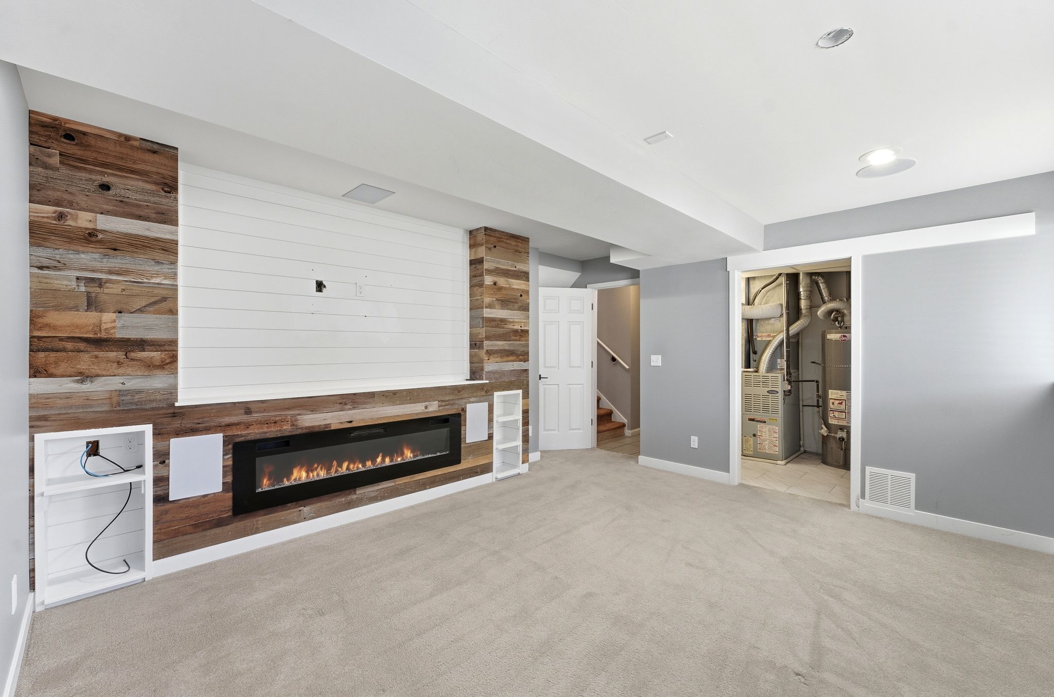 Entertainment wall featuring shiplap and wood-finish paneling, built-in electric fireplace, recessed lighting, and integrated sound system