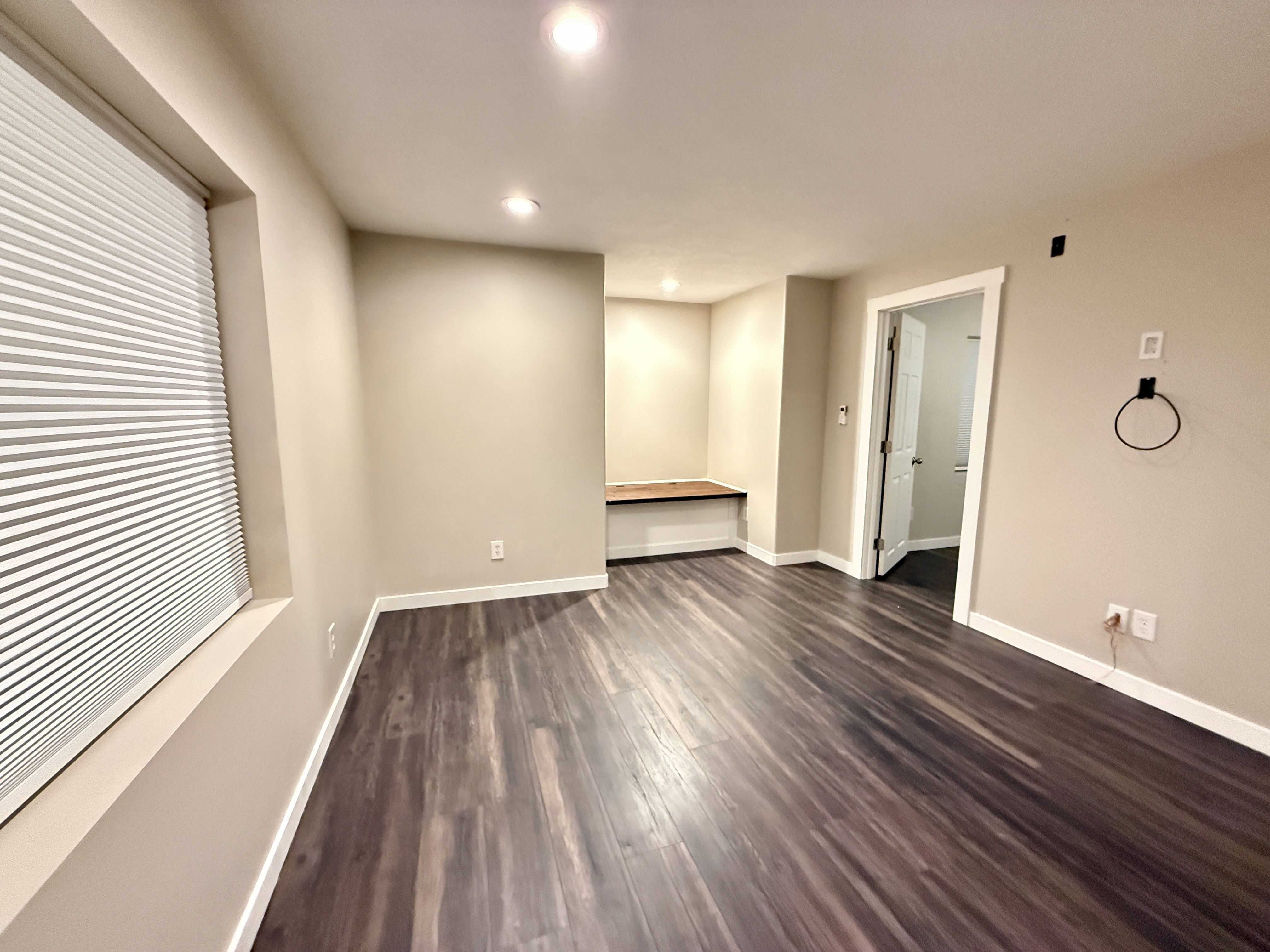 Spacious room featuring wood-finish flooring, recessed lighting, and neutral wall tones