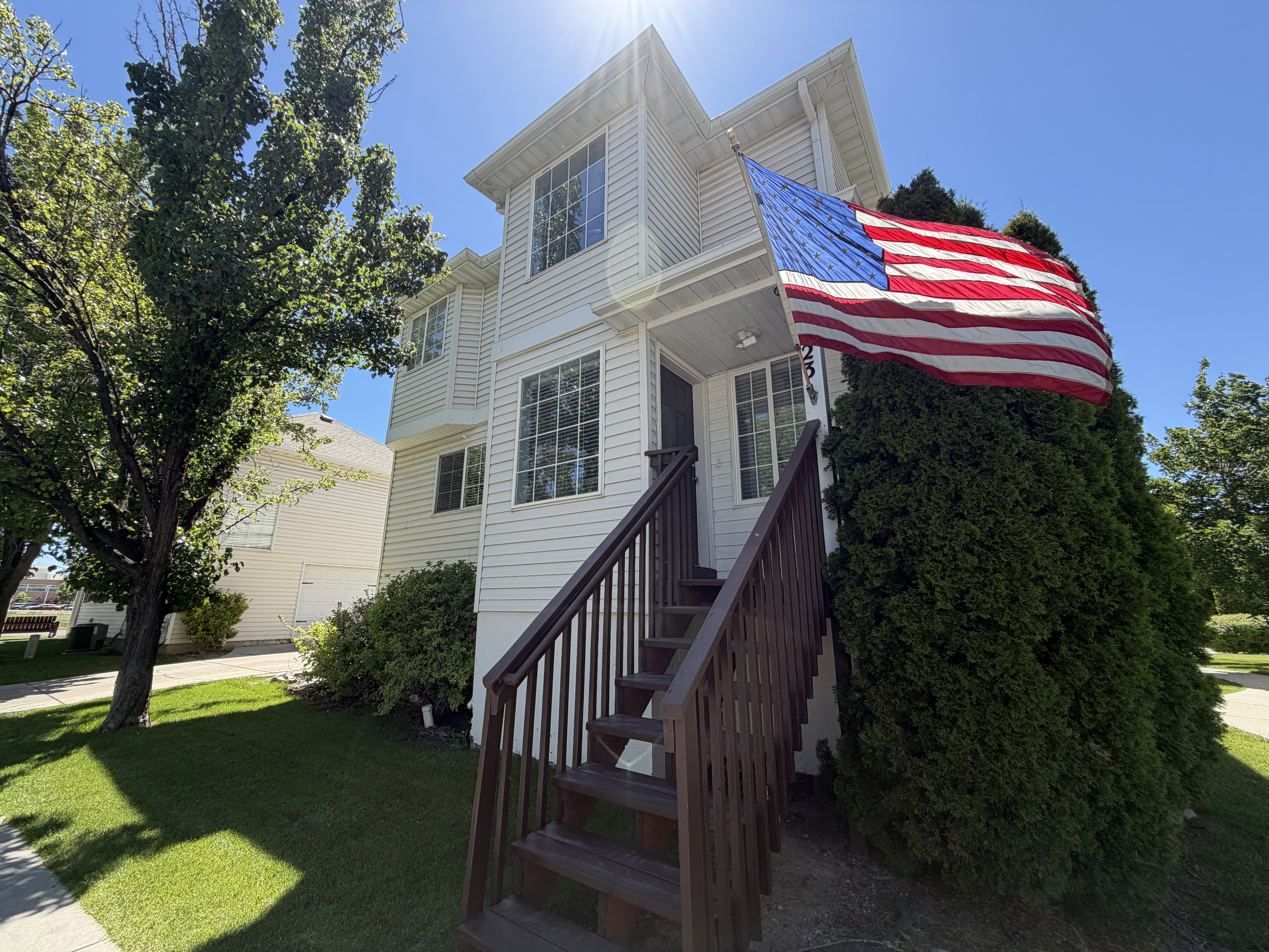 Two-story residence featuring white siding and prominent bay windows