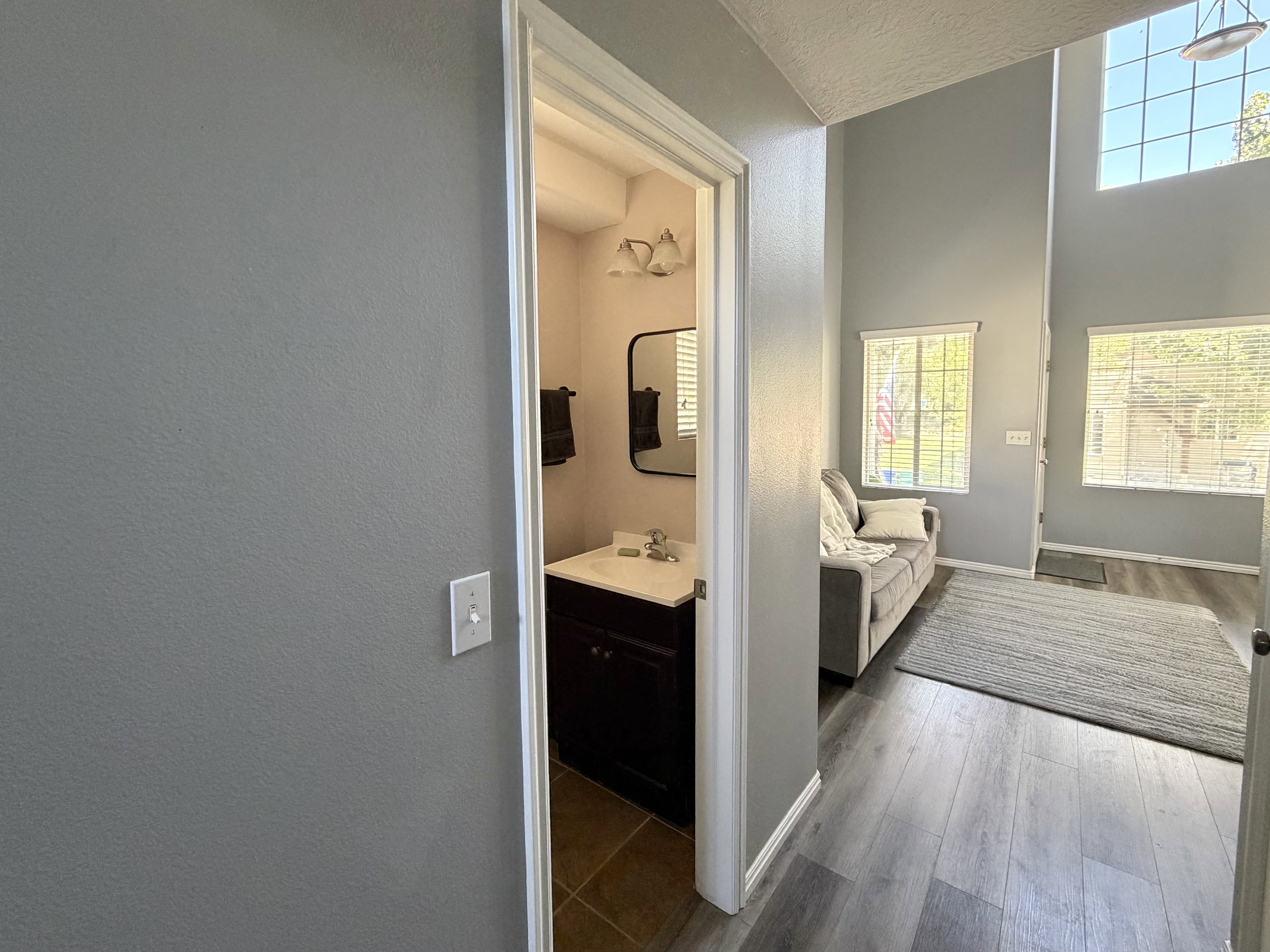 Two-story foyer with high ceilings, large windows, and wood-finish flooring