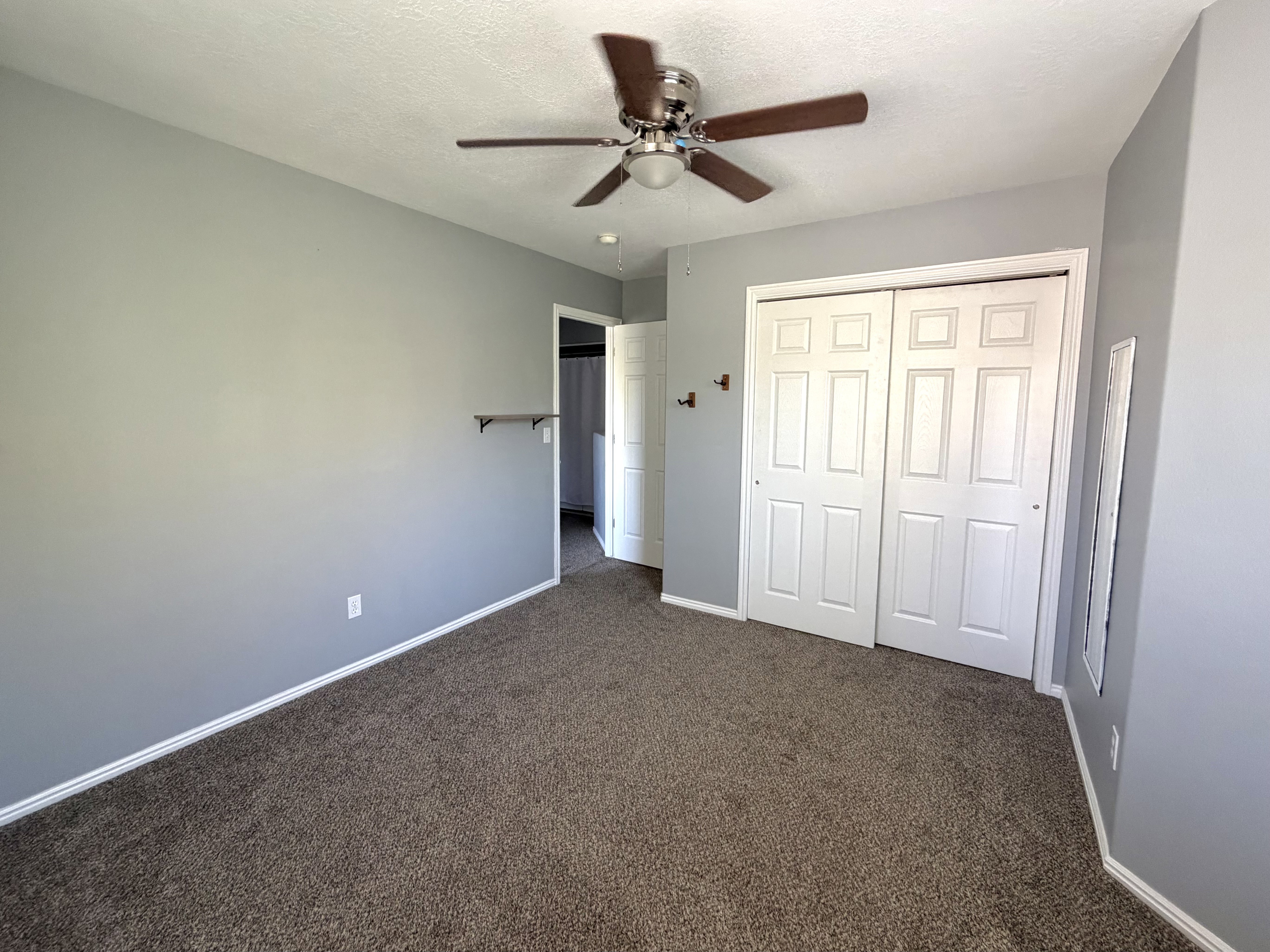 Neutral gray walls complement the brown carpet flooring in this room