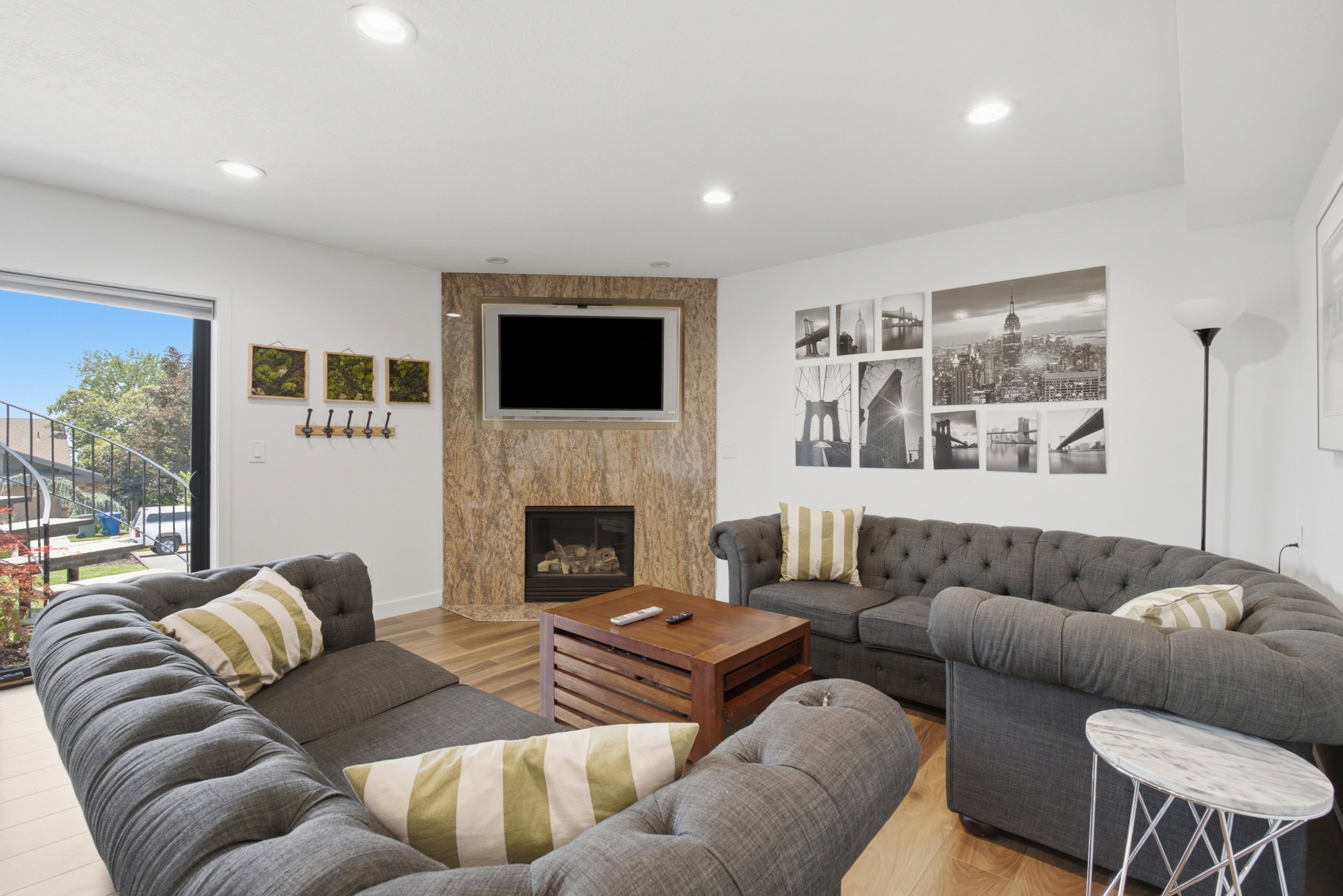 Living area featuring a textured stone fireplace surround, inset fireplace, and wall-mounted television